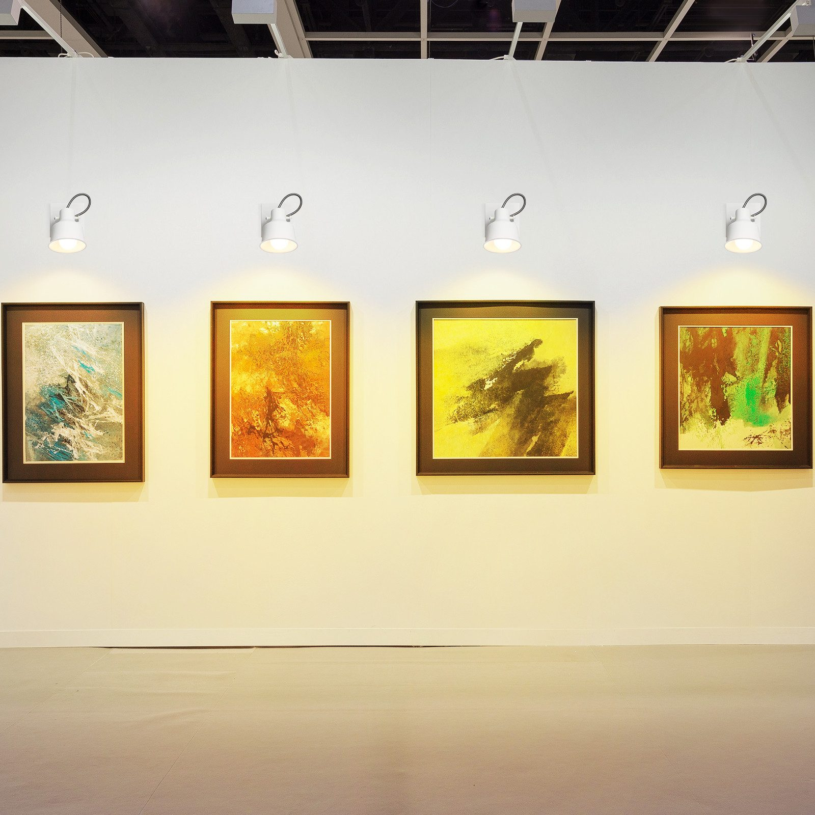 Galleria d'arte con quattro dipinti incorniciati e faretti.