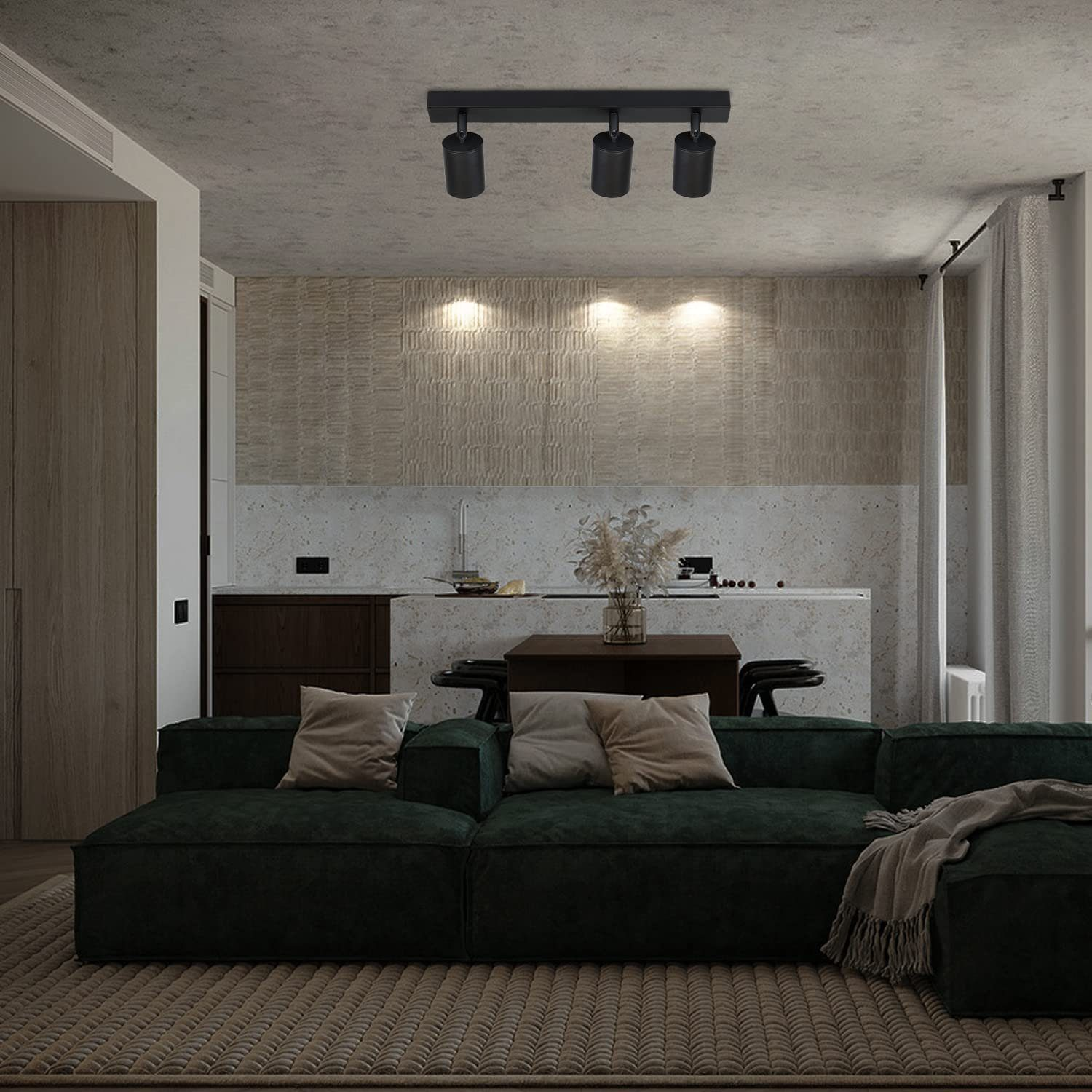 Salon z zieloną sofą, dywanem i oświetleniem szynowym, neutralne tło.