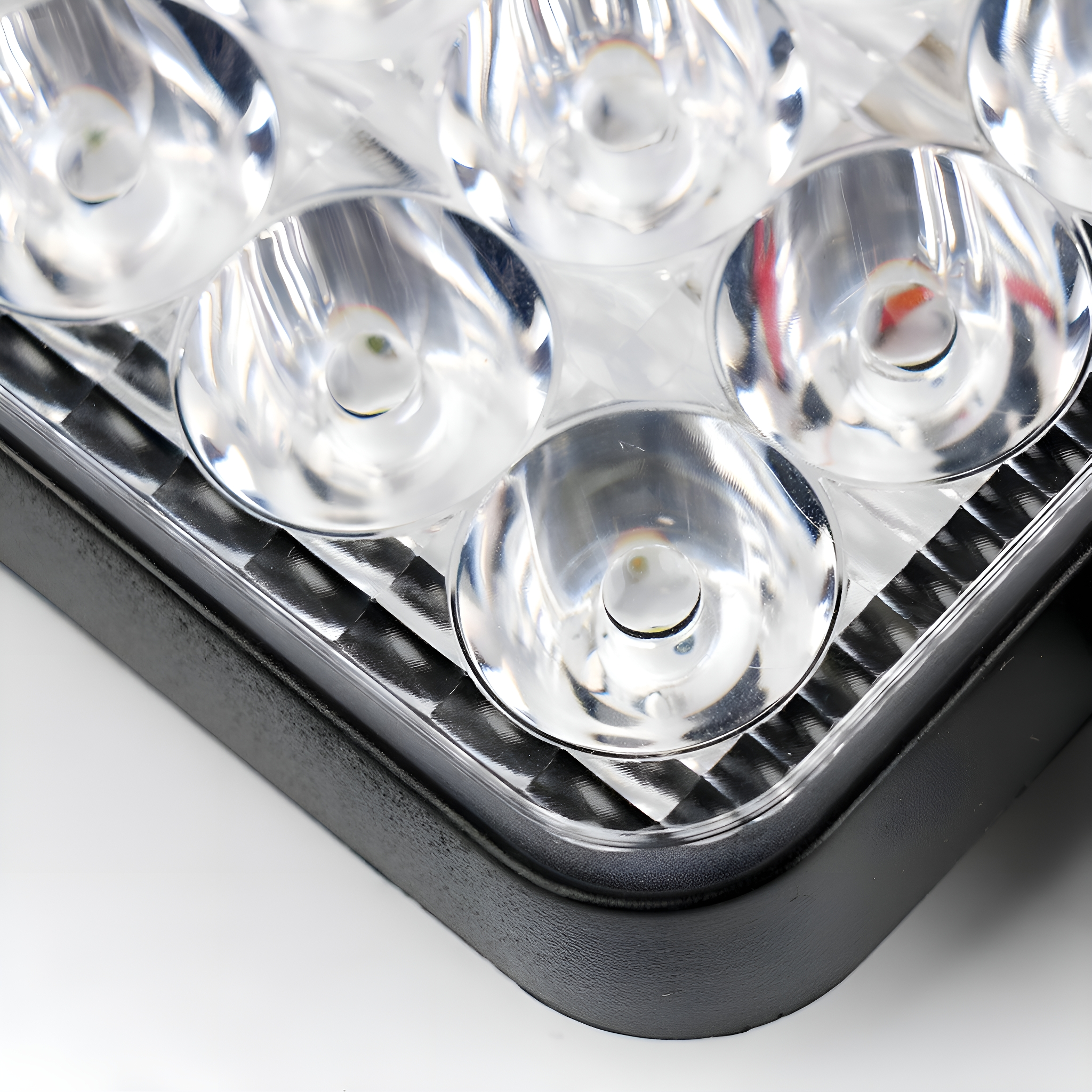 Nahaufnahme eines transparenten LED-Lichtpanels mit mehreren Linsen und schwarzem Rahmen.