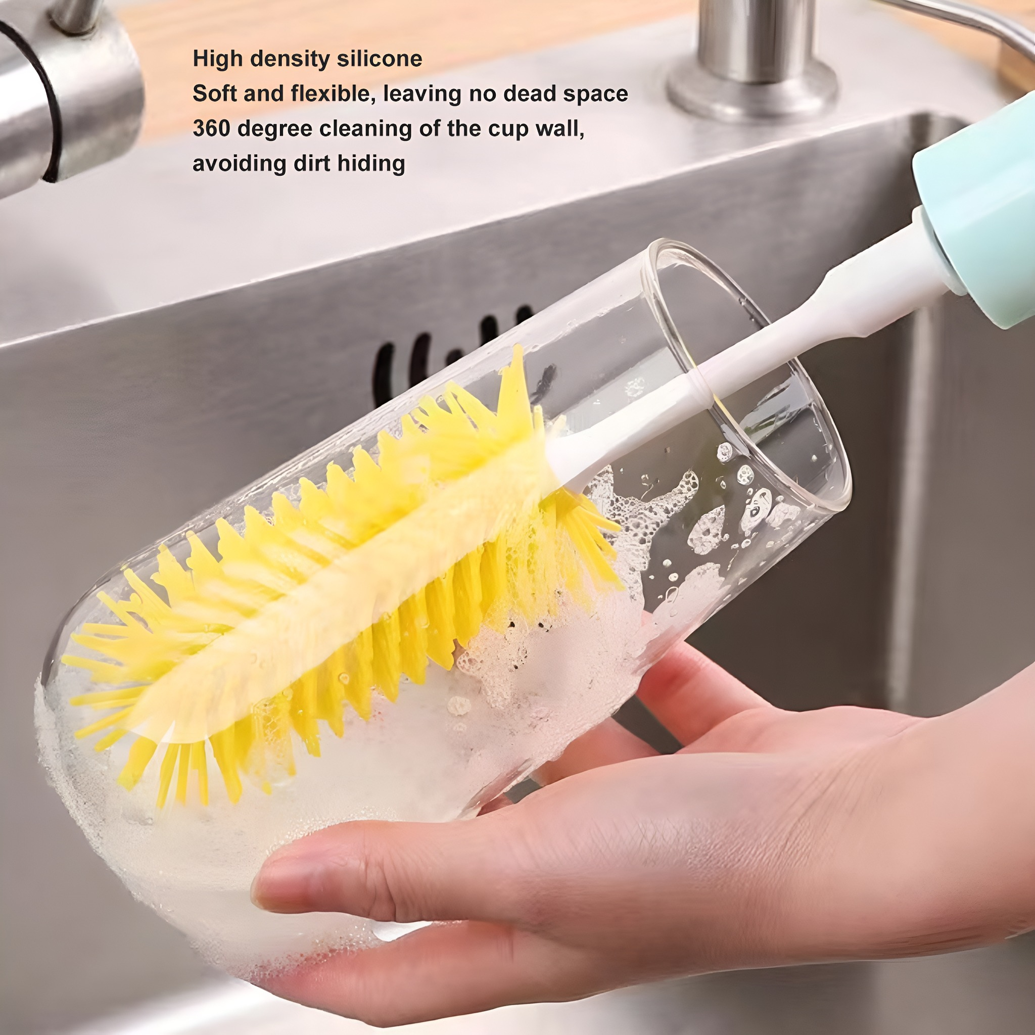 Hand reinigt Glas mit gelber Bürste im Waschbecken. Wasser und Seife sichtbar.