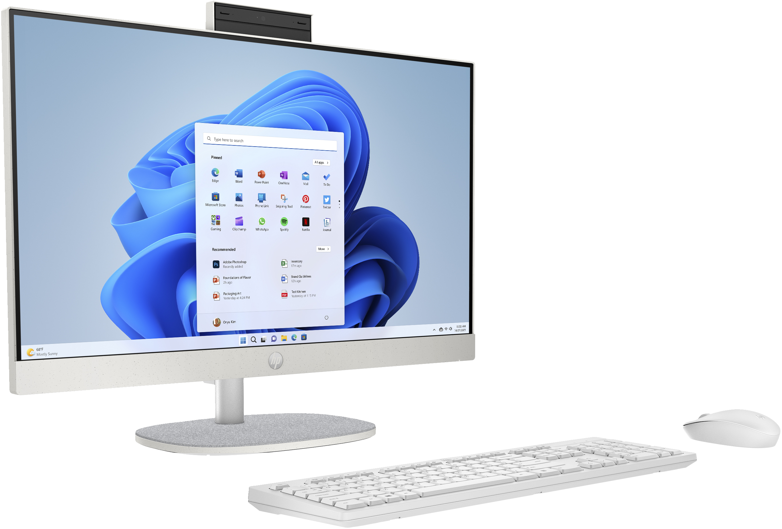 White all-in-one PC with screen showing Windows 11 interface, keyboard and mouse.