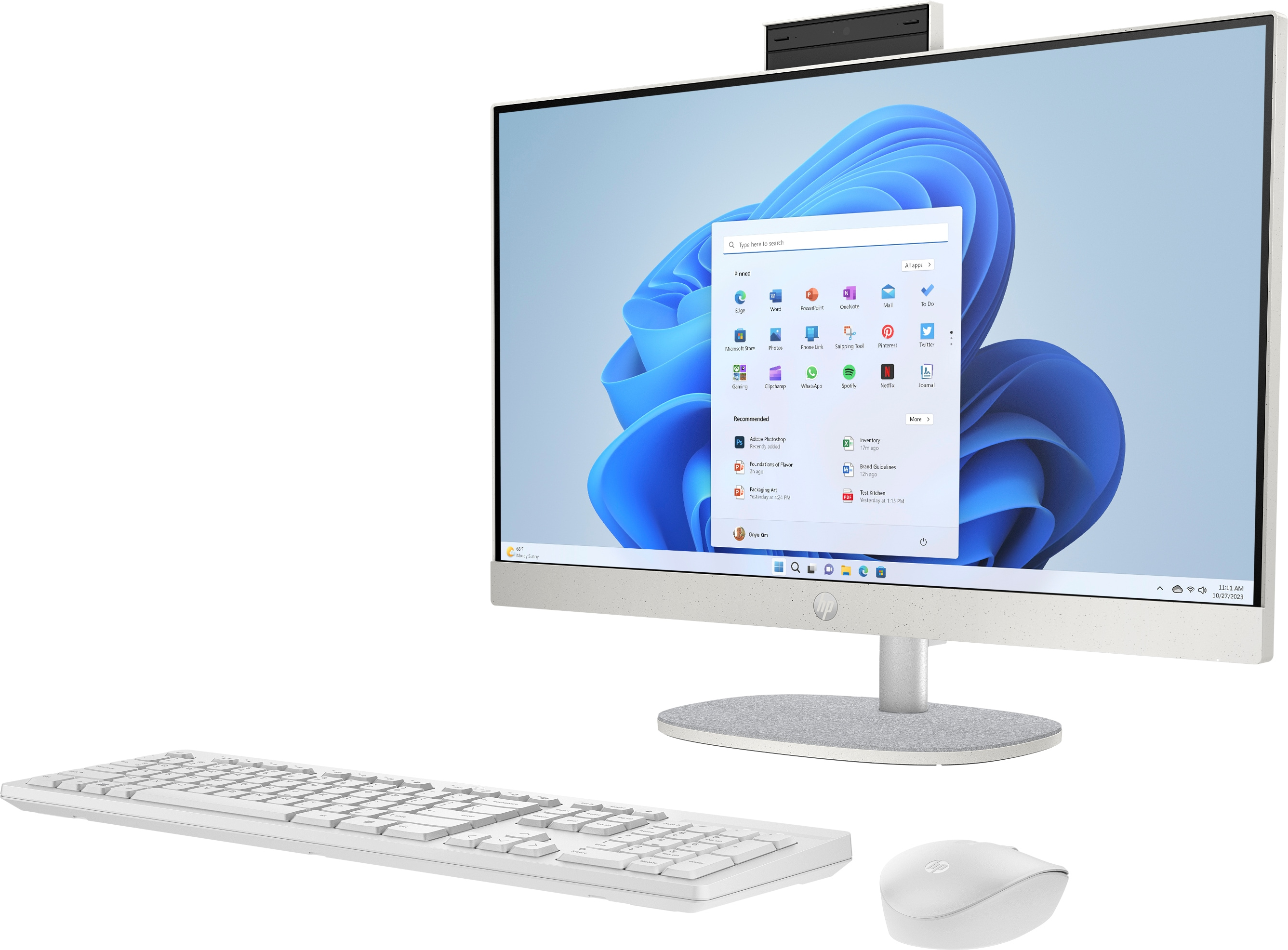 White all-in-one computer showing a Windows 11 interface. Keyboard and mouse are present.