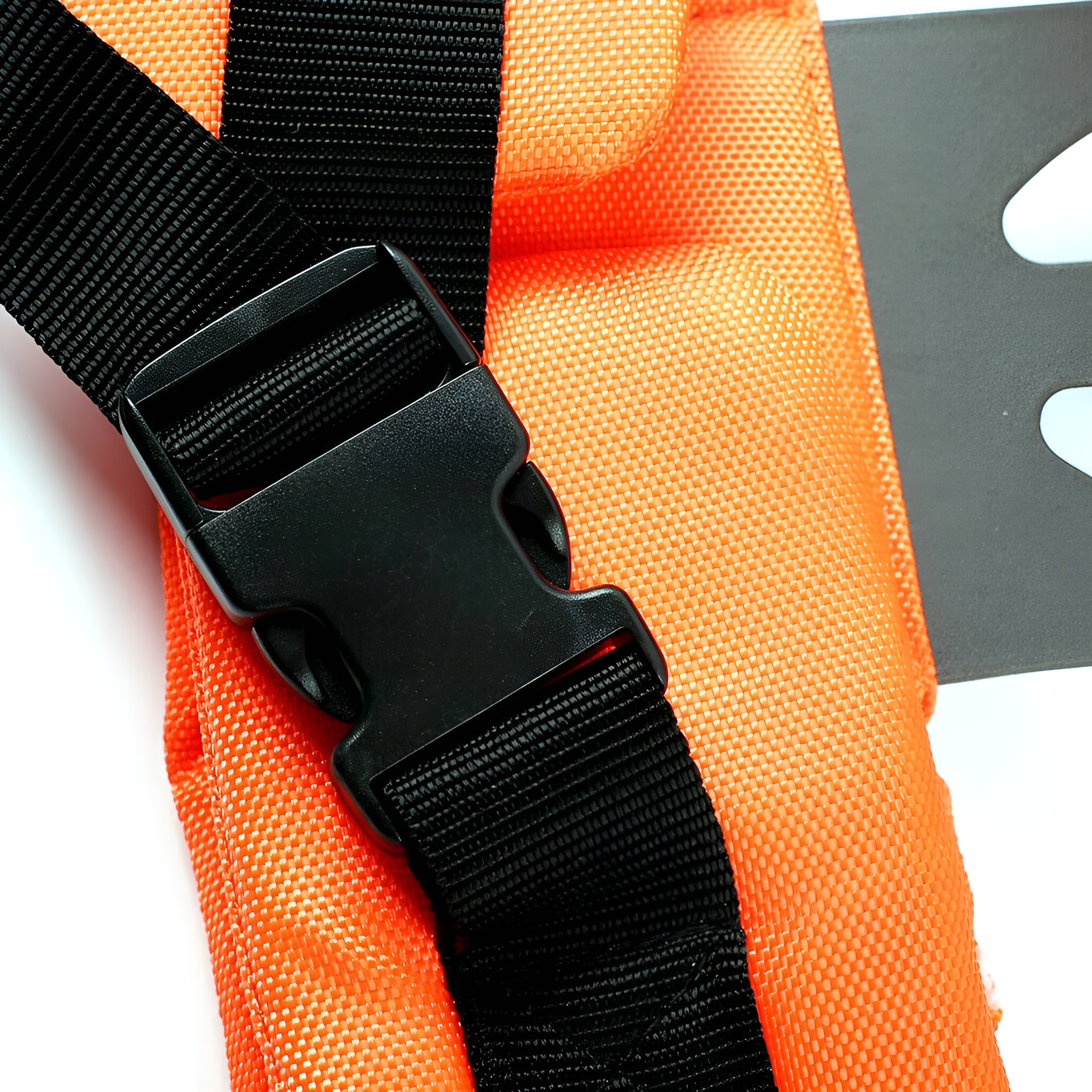 Nahaufnahme einer orangefarbenen Schwimmweste mit schwarzer Schnalle und Riemen, isoliert auf Weiß.