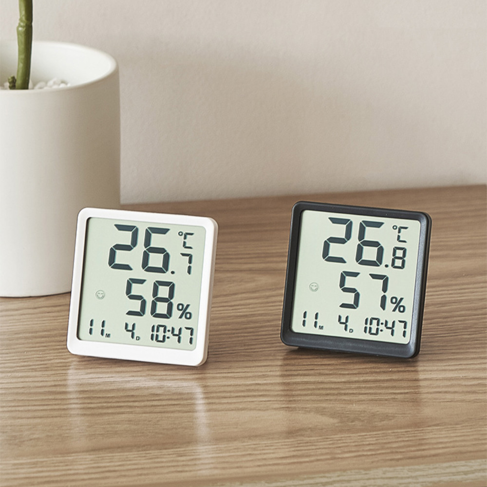 Zwei digitale Thermometer mit Temperatur- und Feuchtigkeitsmesswerten, eines weiß und eines schwarz.