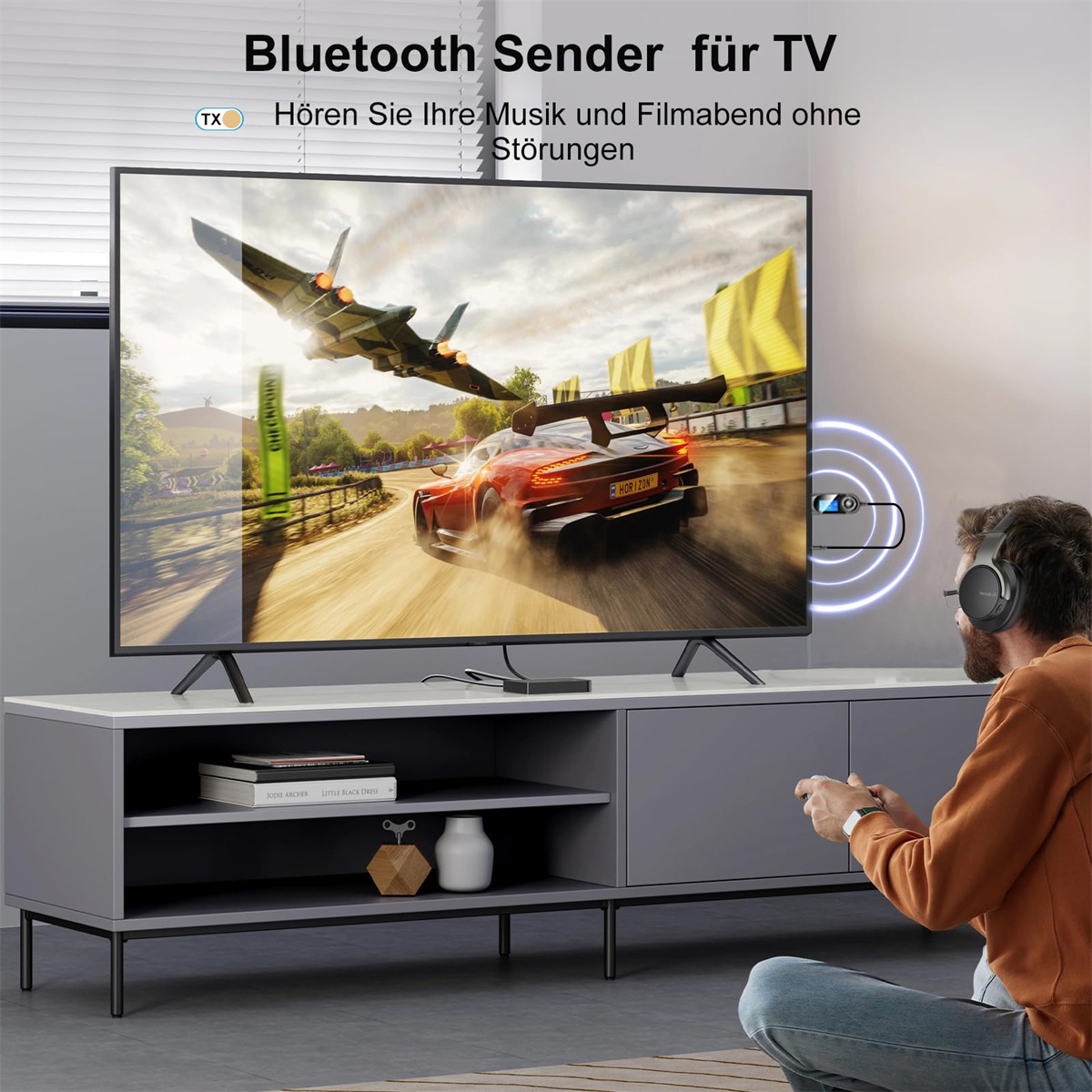 Fernseher zeigt Rennspiel, Mann trägt Kopfhörer, Bluetooth-Sender auf dem TV-Tisch.