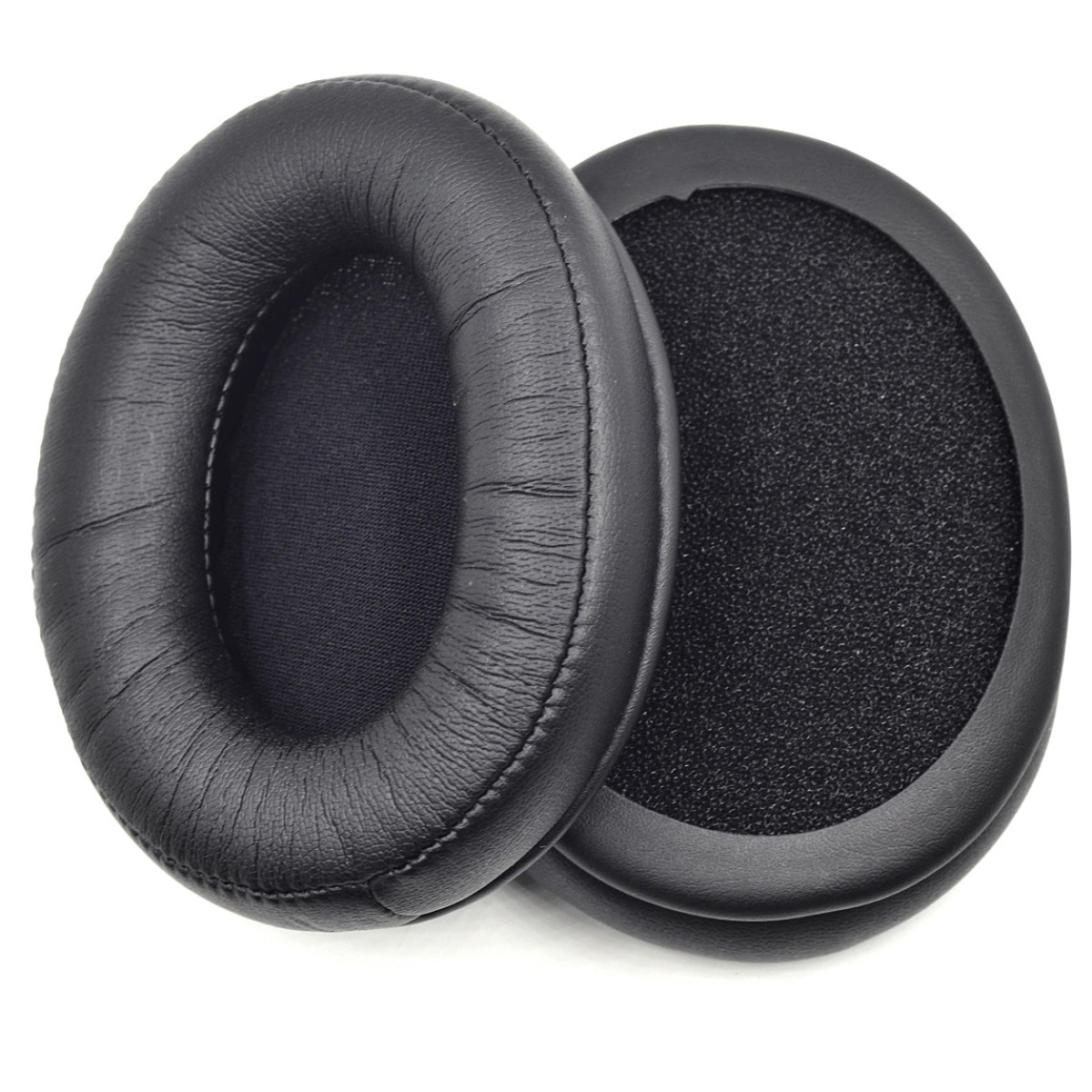 Due cuscinetti auricolari neri, di forma ovale, per cuffie. I cuscinetti sono morbidi e circolari.