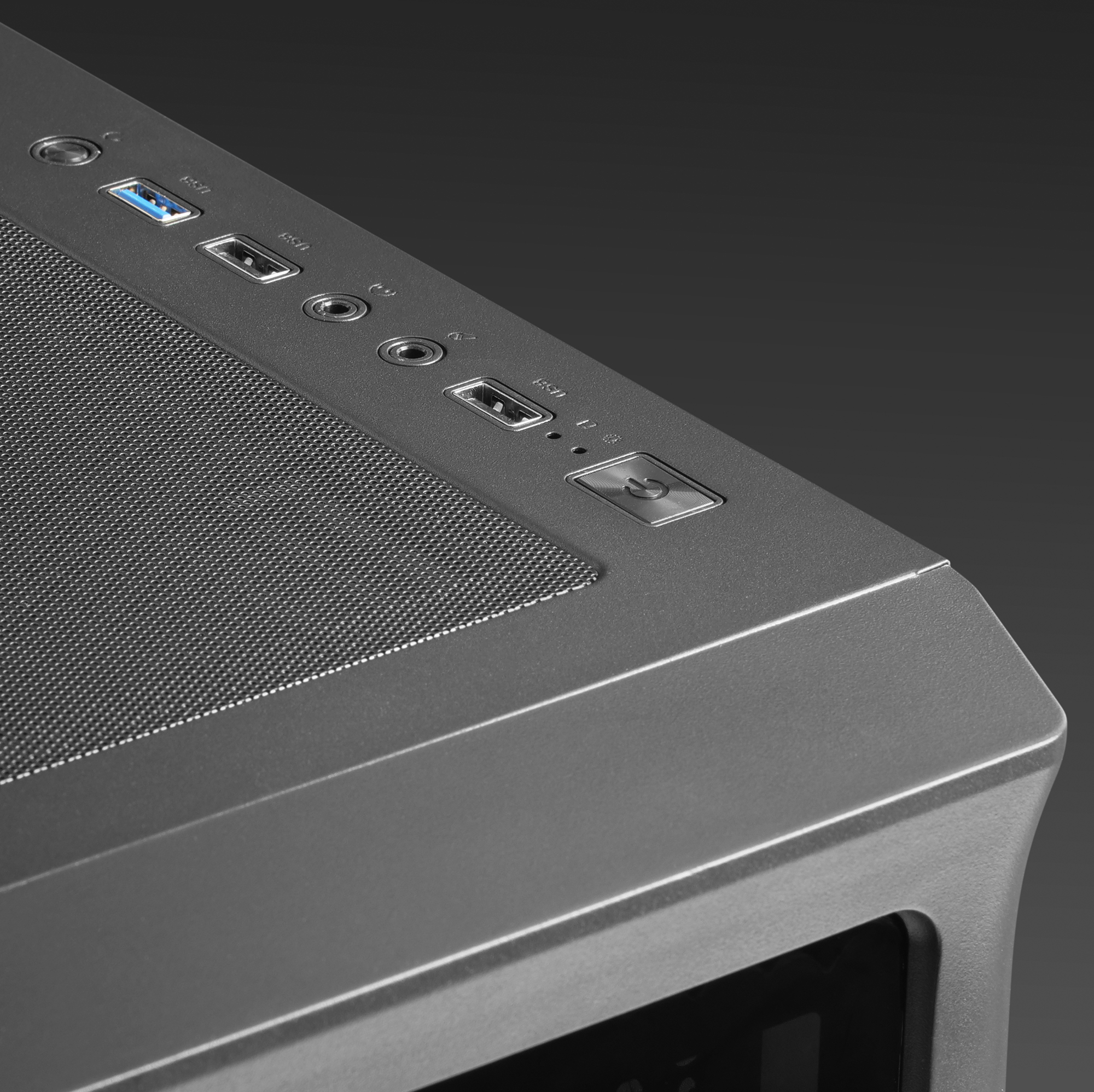 Primo piano del pannello superiore di un case PC grigio con porte USB, pulsanti e fori di ventilazione.