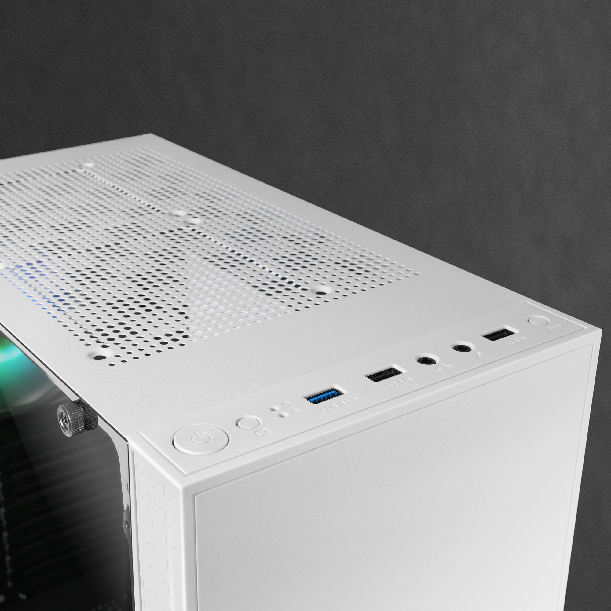 Parte superiore del case del computer bianco con pulsante di accensione, porte USB e jack audio. È visibile una presa a rete.
