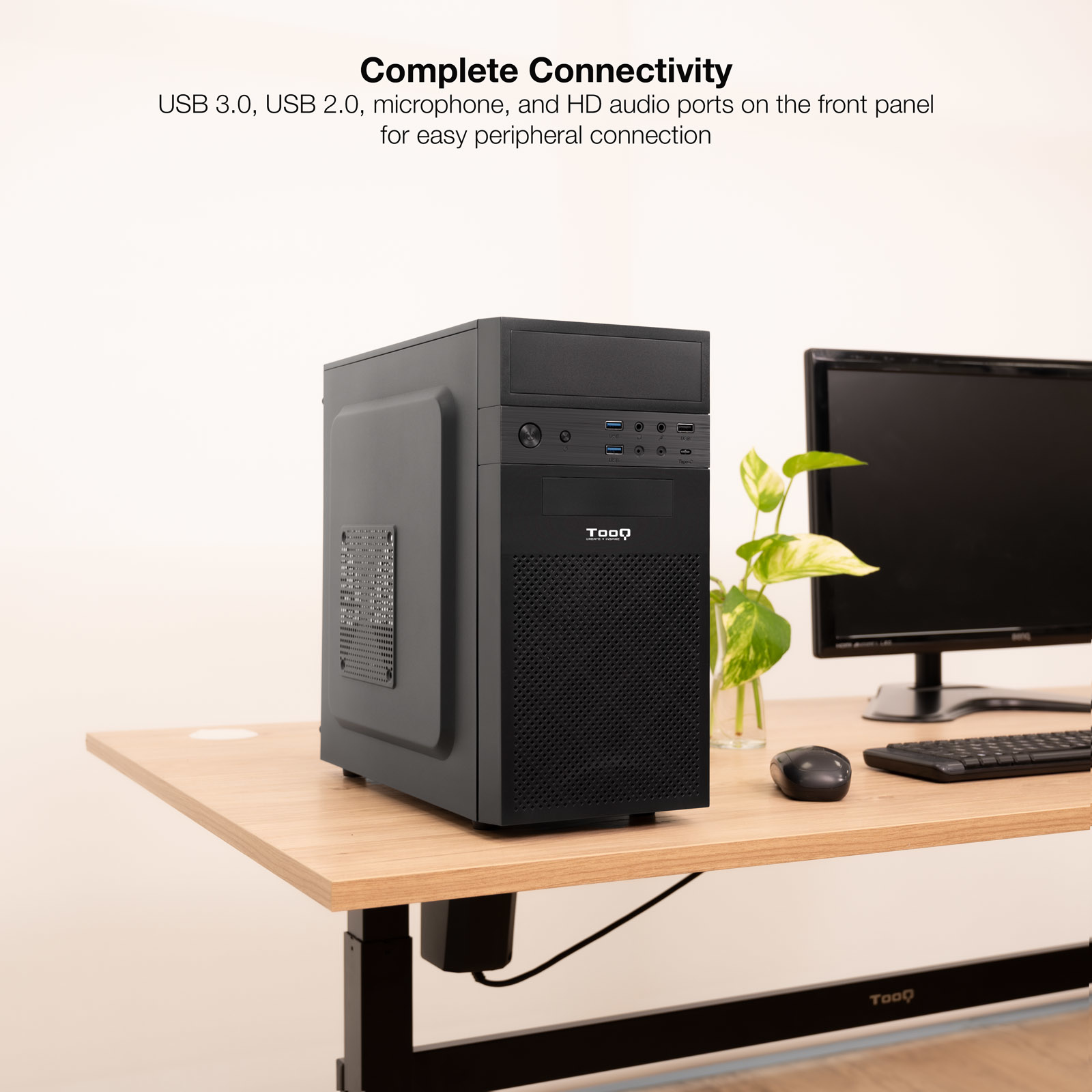 Case PC nero su scrivania in legno. Monitor, mouse e pianta presenti.