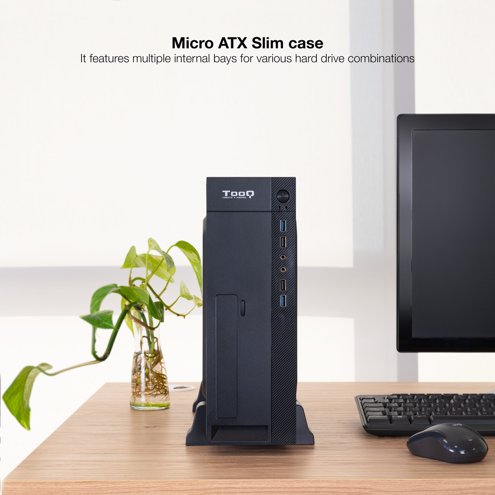 Case PC Micro ATX Slim nero con pianta, monitor, tastiera e mouse sulla scrivania.