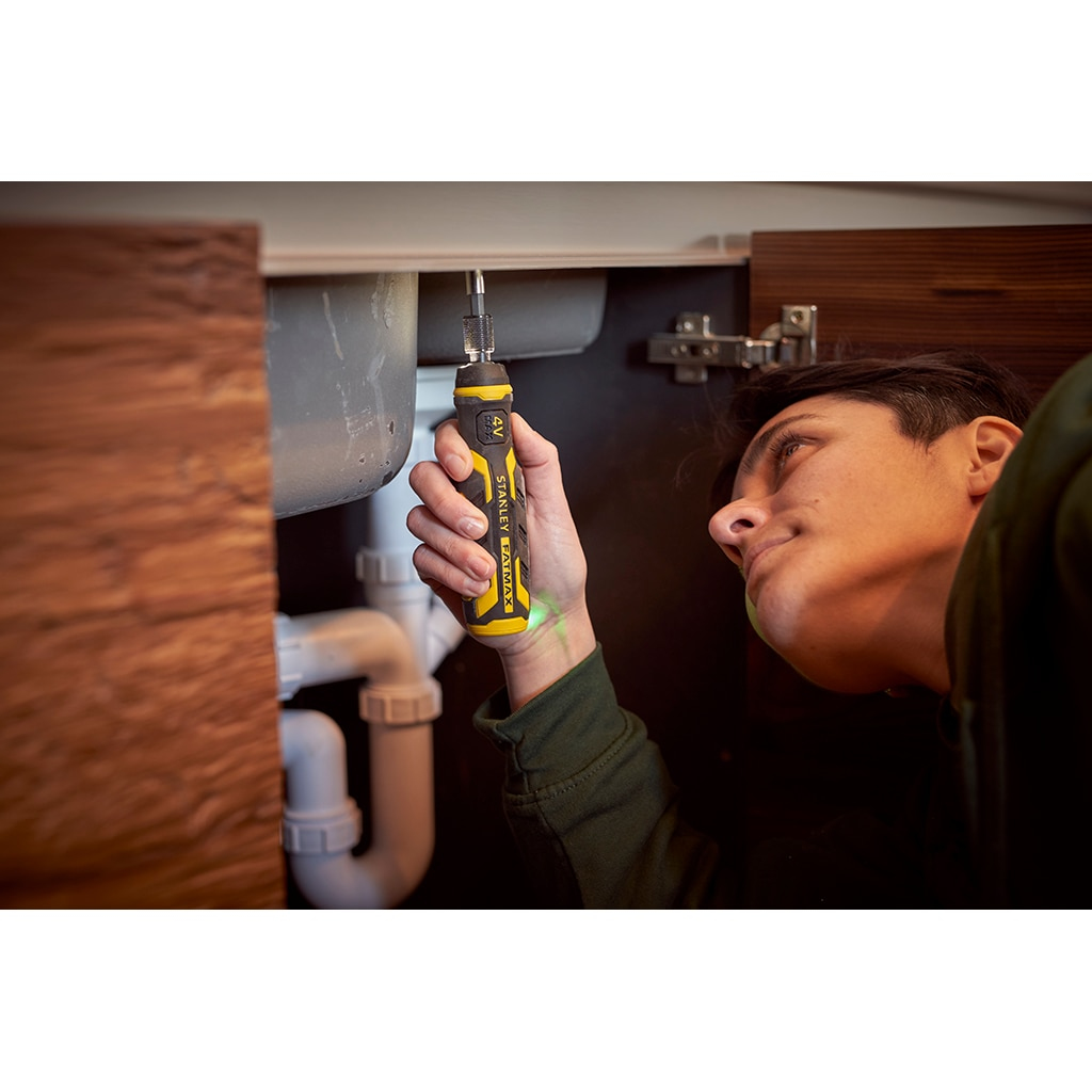 Eine Person benutzt einen elektrischen Schraubendreher von Stanley Fatmax unter einem Waschbecken.