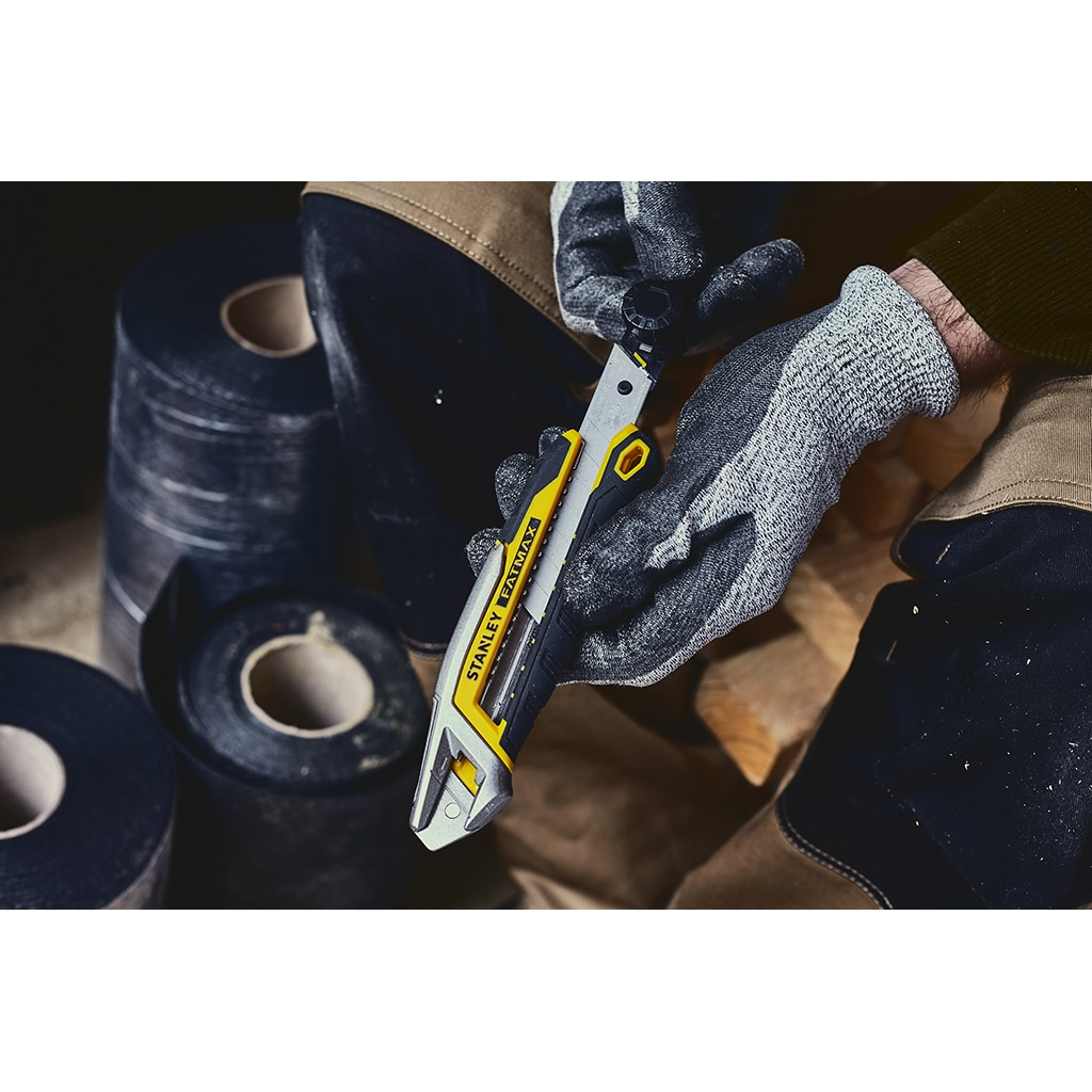 Hand im Handschuh, die ein Stanley FatMax-Messer zum Schneiden benutzt. Klebebandrollen im Hintergrund.