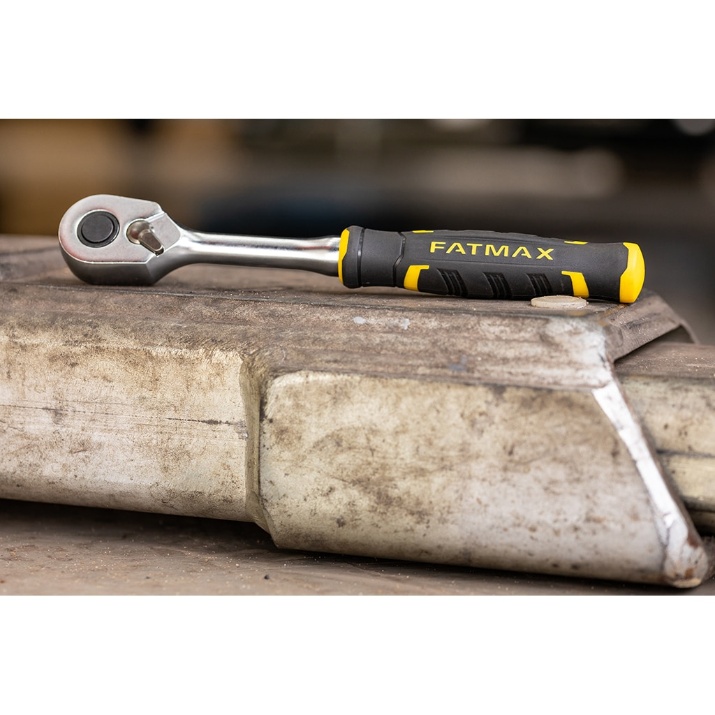 Una llave de carraca FATMAX sobre una superficie metálica desgastada.
