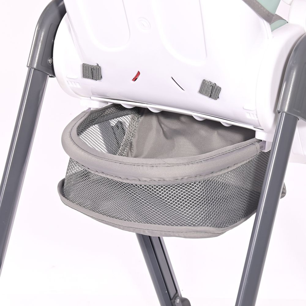 Ein Babyhochstuhl mit einem grauen Netz-Aufbewahrungskorb. Der Stuhl ist hauptsächlich weiß mit grauen Stützbeinen.