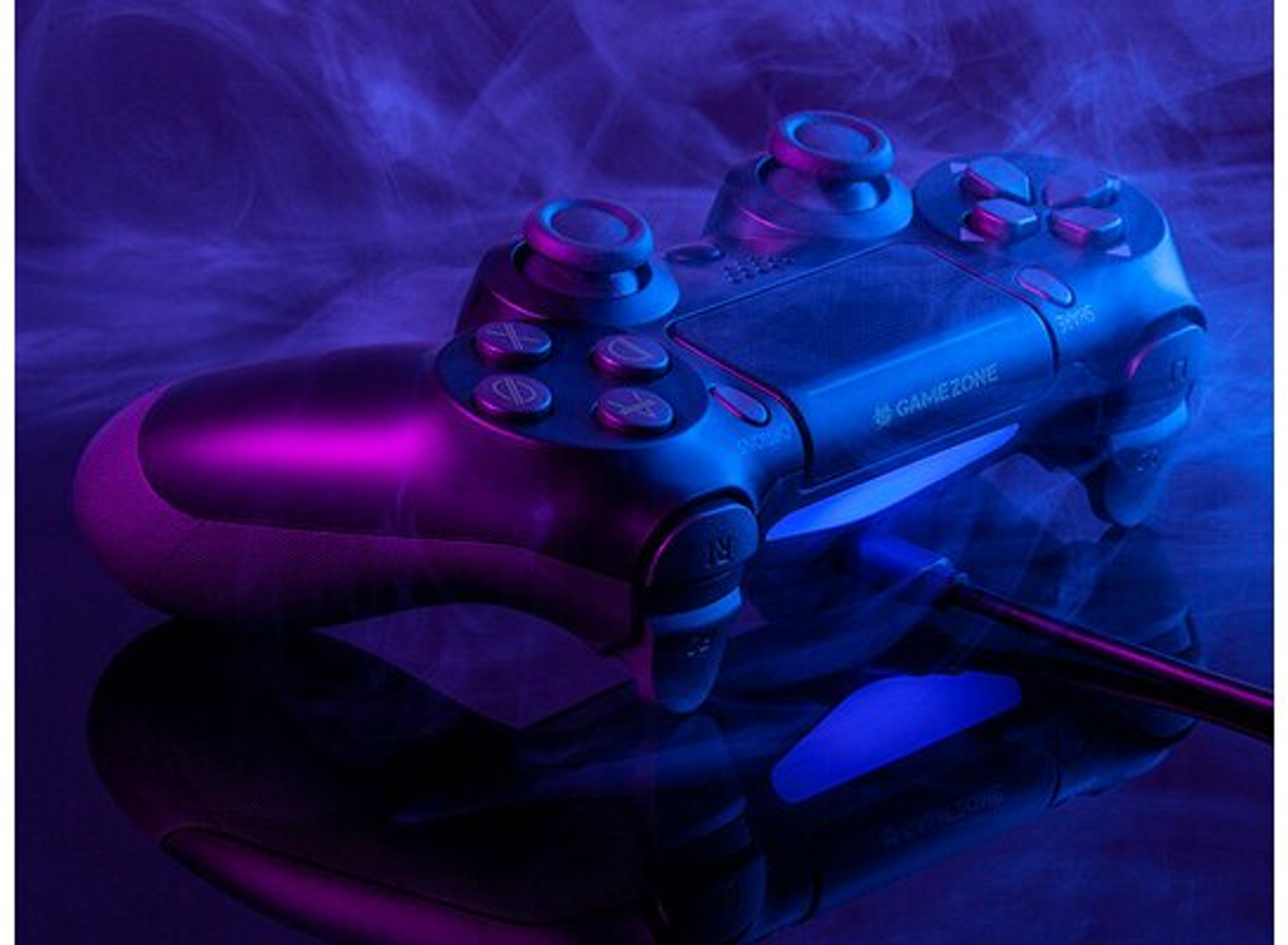 Un controller per videogiochi nero con illuminazione viola e blu, su una superficie riflettente.
