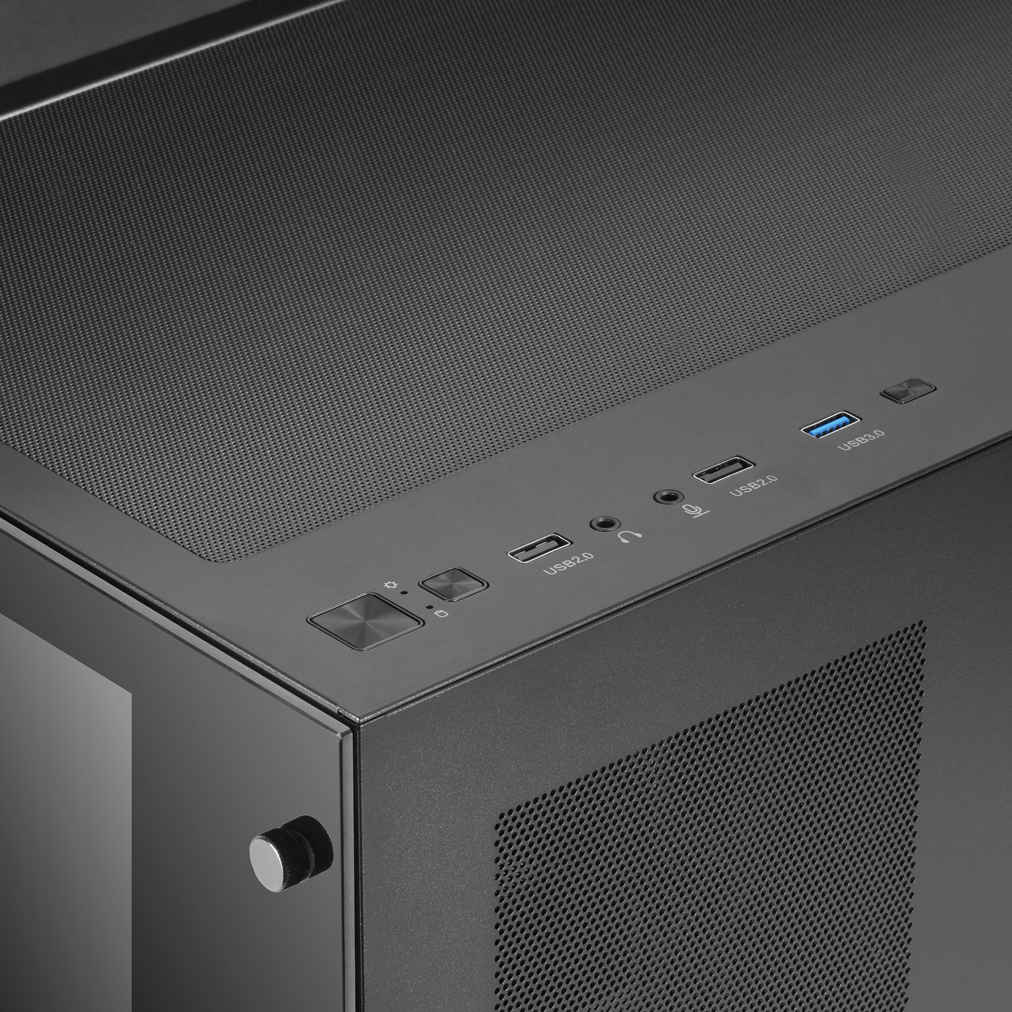 Róg czarnej obudowy komputera. Widoczne porty, przyciski i sekcja siatki.
