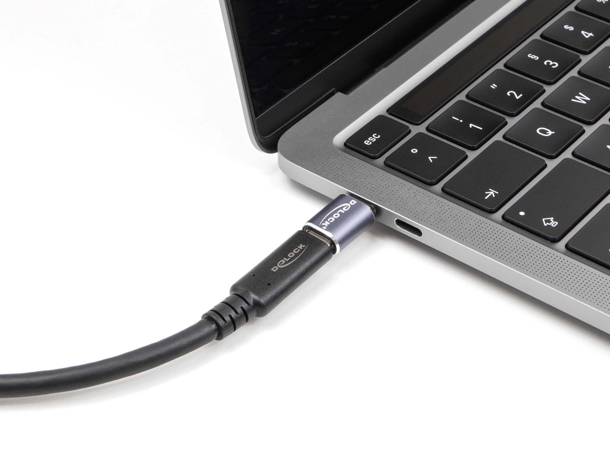 USB-C-Kabel, das mit einem Laptop auf weißer Oberfläche verbunden ist.