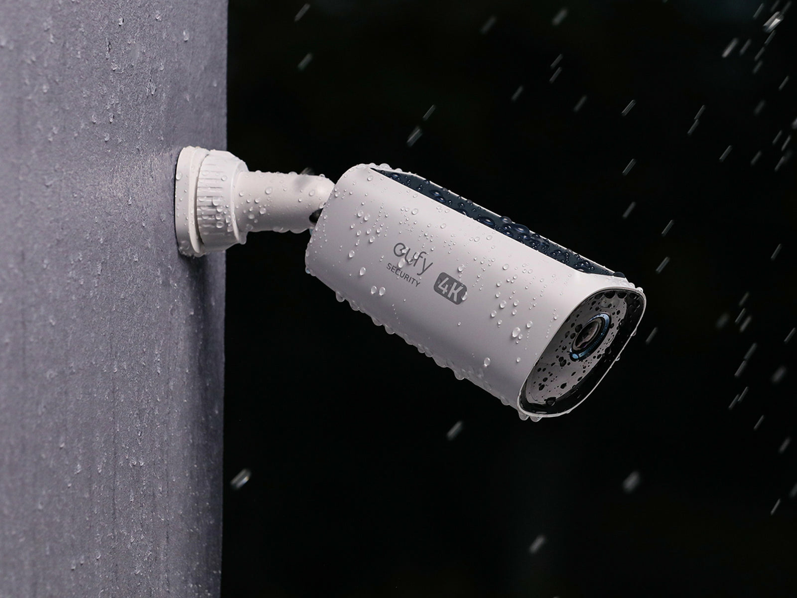 Biała kamera bezpieczeństwa zamontowana na ścianie, wystawiona na deszcz. Marka eufy.