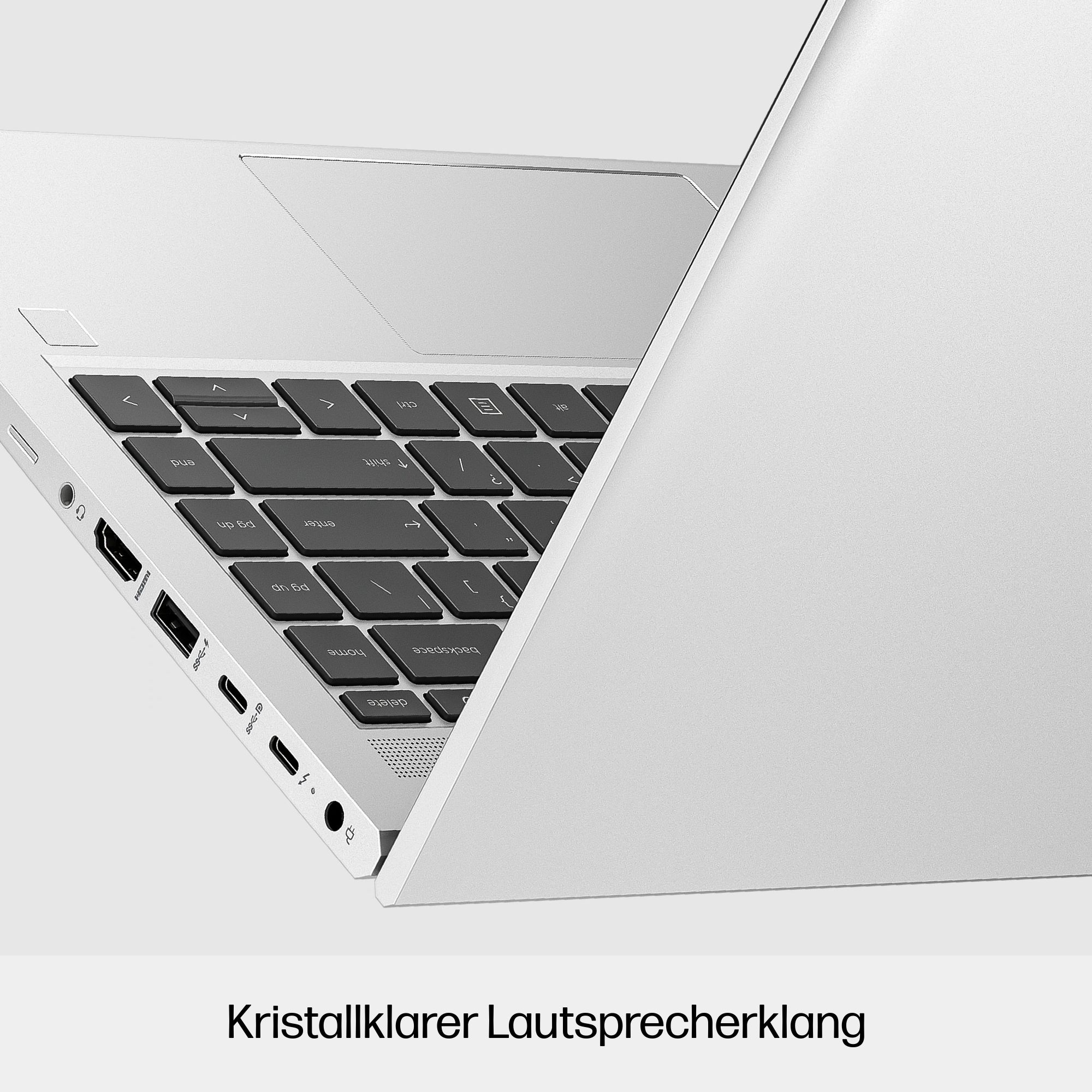 Ein silberner Laptop mit Tastatur und offenem Bildschirm. Die Tastatur ist sichtbar, und der Text lautet: „Kristallklarer Lautsprecherklang“.