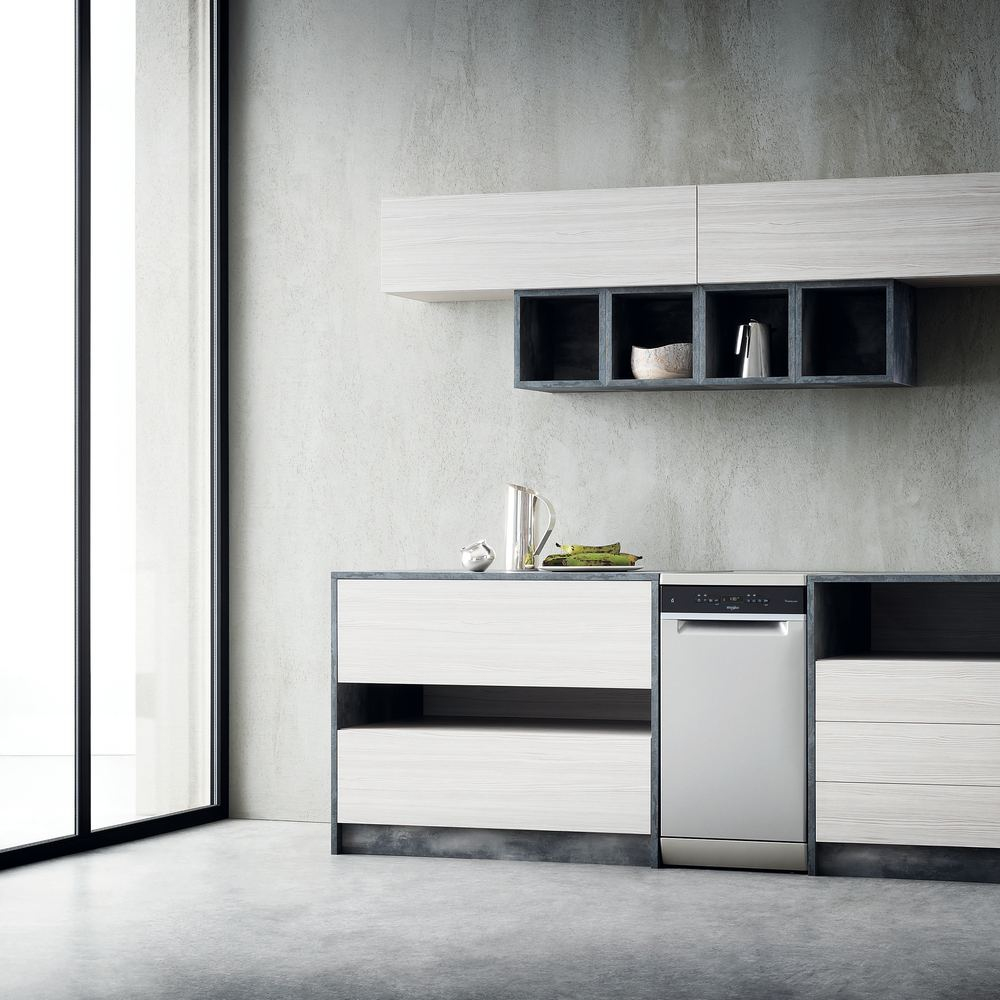 Kuchnia ze zmywarką, białymi szafkami i dużym oknem po lewej stronie.