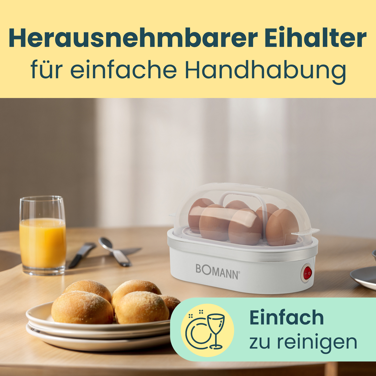 Gotowacz do jajek z jajkami w środku, sok pomarańczowy, bułki i łyżka.