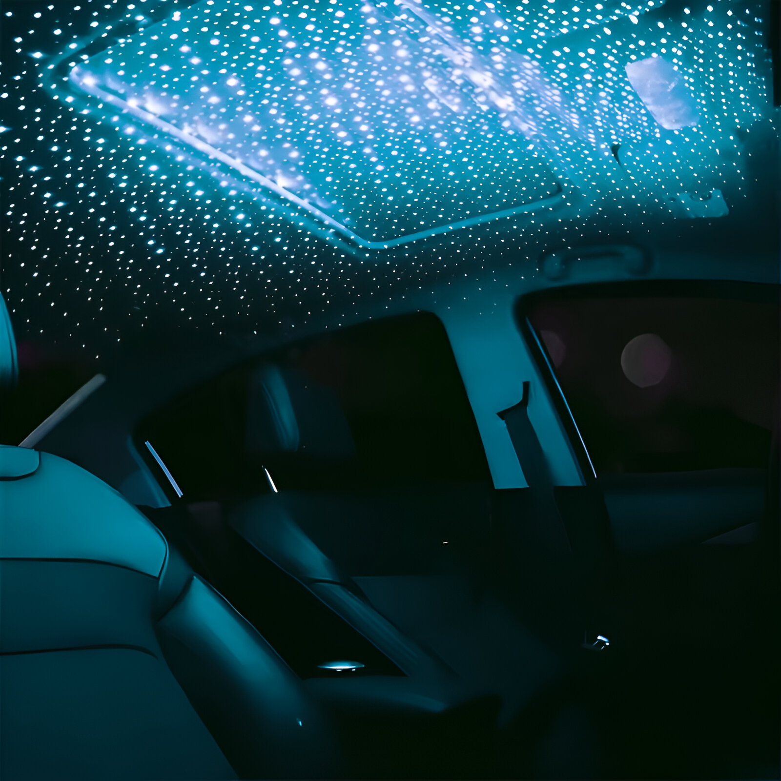 El interior de un coche de noche, con un techo estrellado y asientos oscuros.