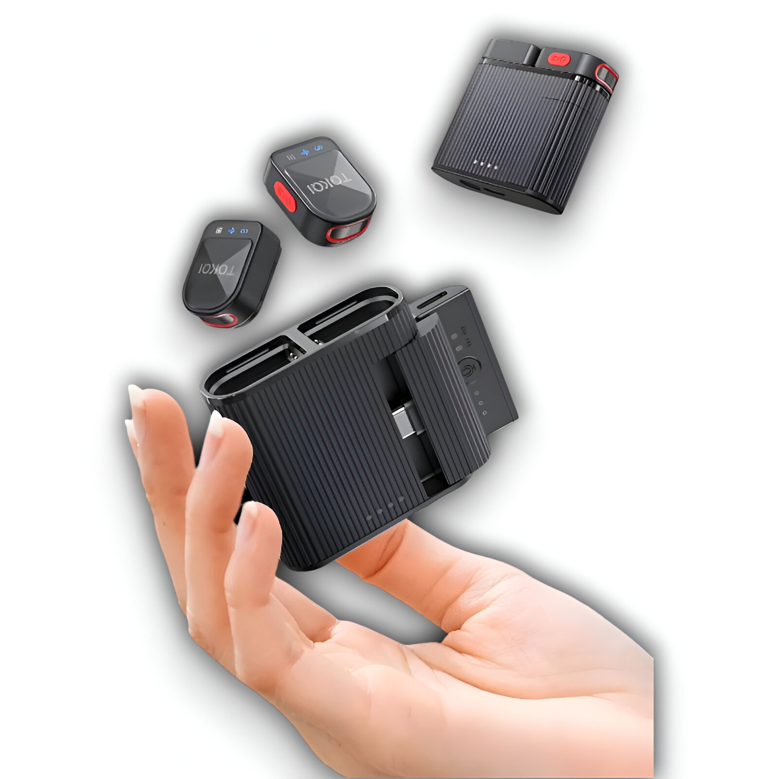Mano sosteniendo dispositivos de audio negros y rojos. Tres dispositivos más pequeños y una estación de carga.