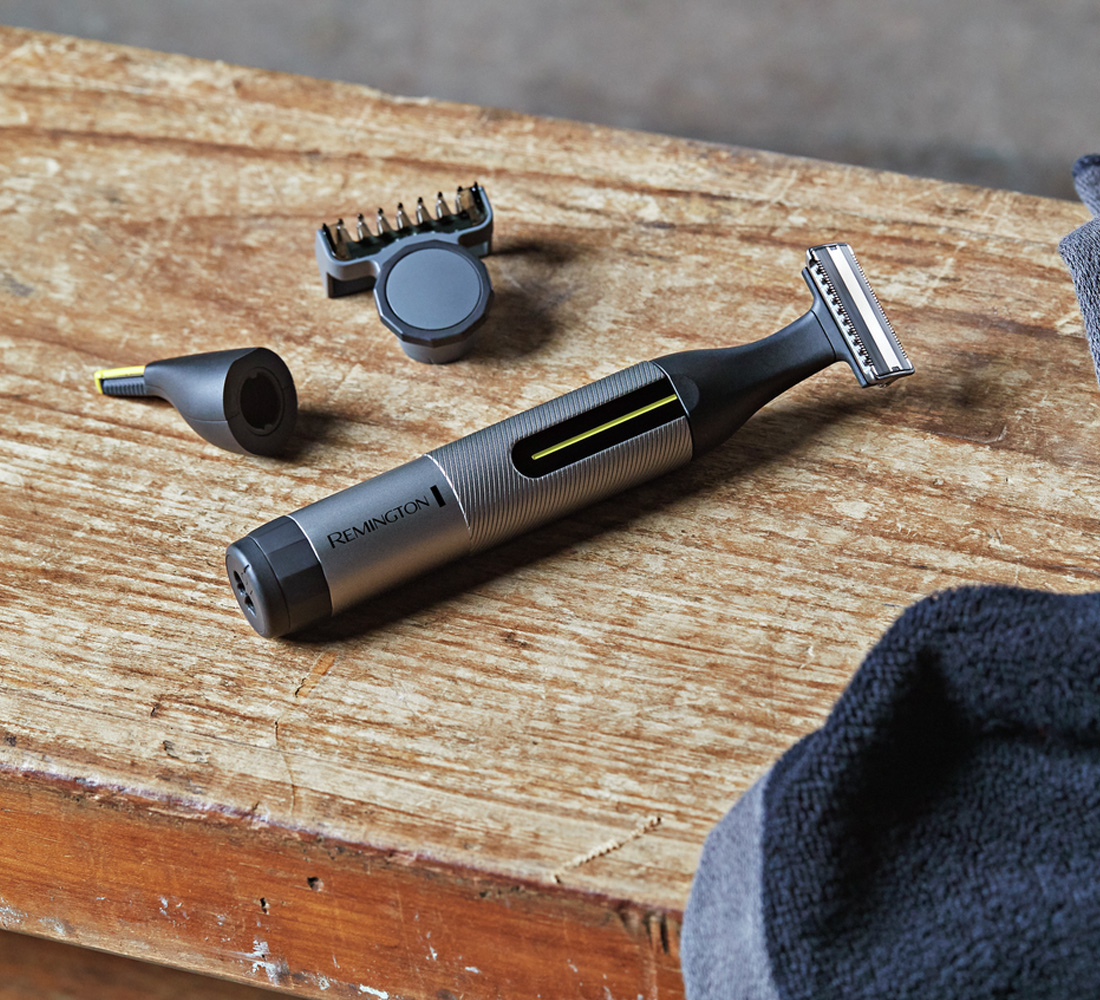 Remington Barttrimmer und Zubehör auf Holzoberfläche mit Handtuch.