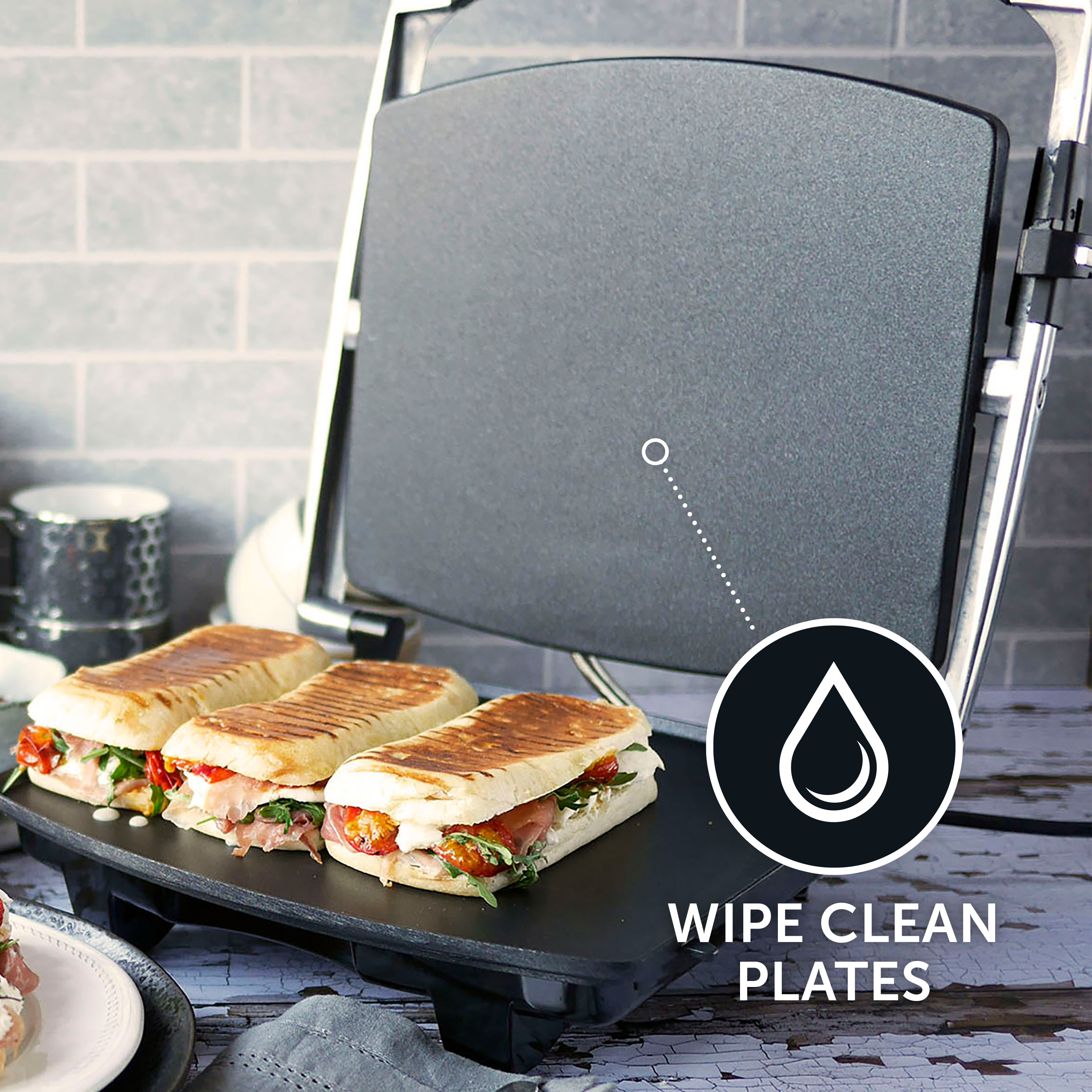 Panini-Presse mit drei Sandwiches, leicht zu reinigende Platten. Sandwiches haben Füllungen.