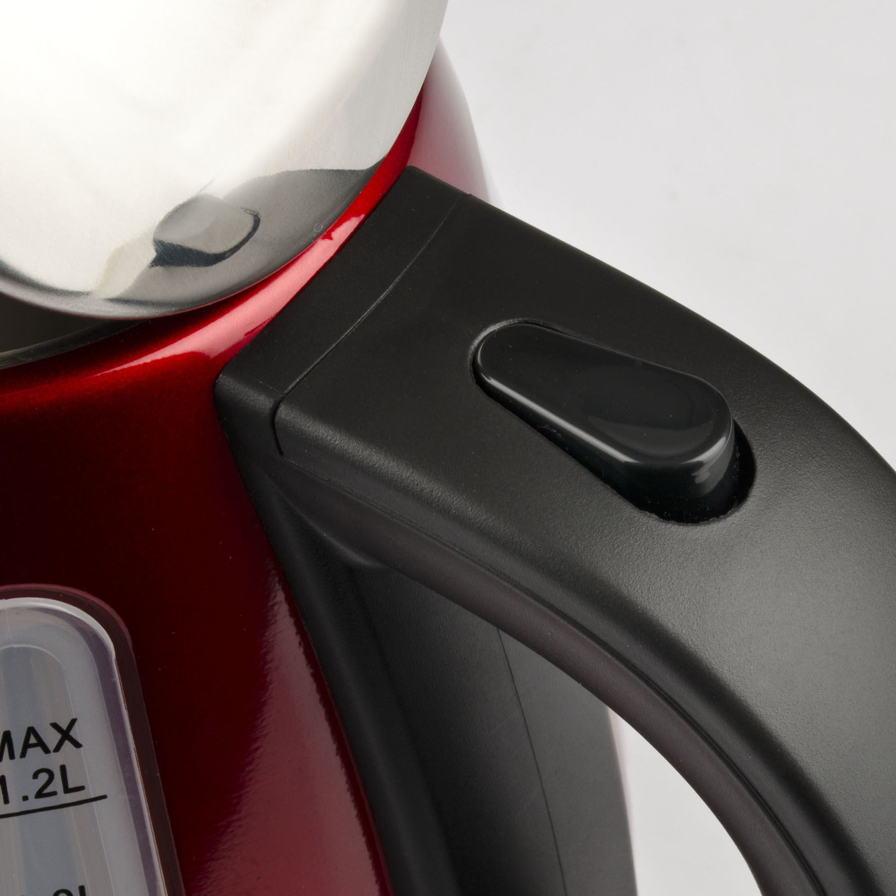 Zbliżenie czerwono-czarnego czajnika z czarnym uchwytem.