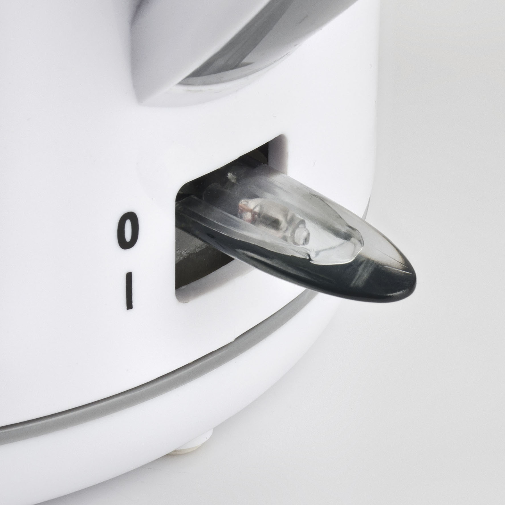 Zbliżenie białego urządzenia z przezroczystym, podświetlanym włącznikiem/wyłącznikiem.