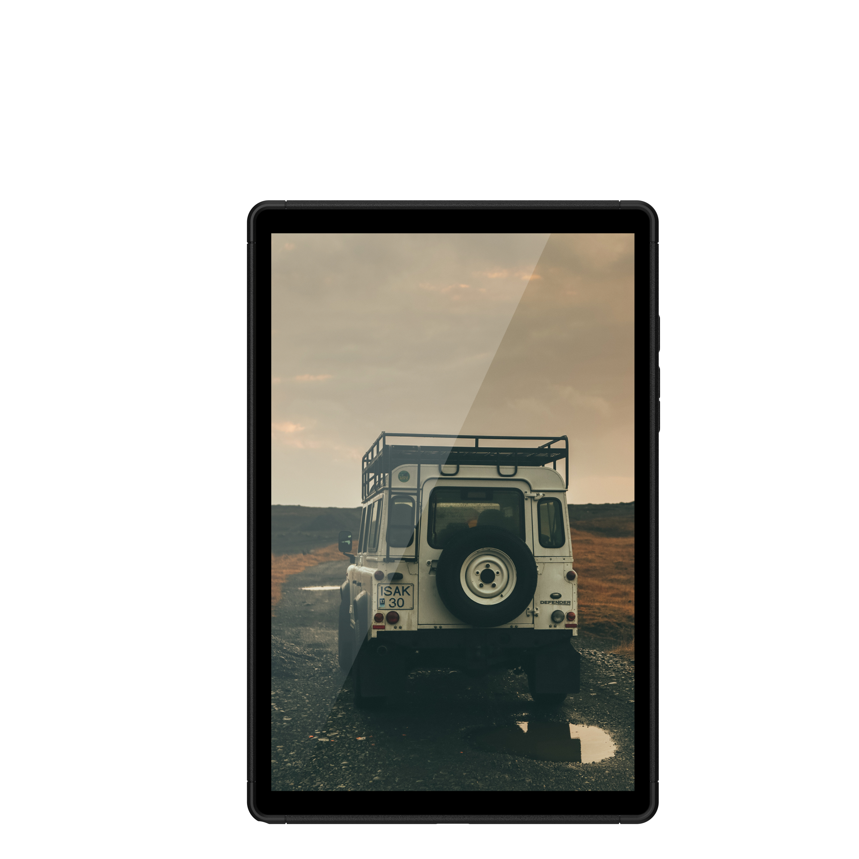 A tablet displaying a white Land Rover Defender on a dirt road.