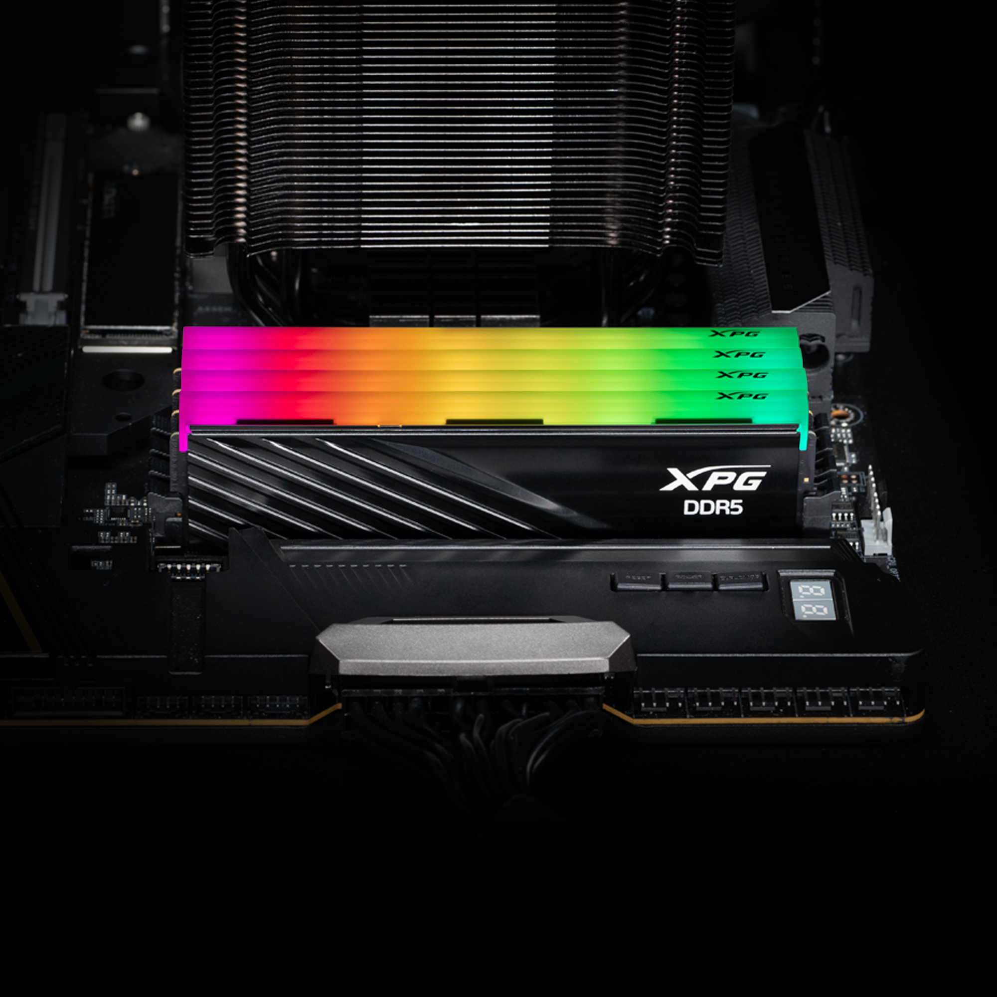 Moduł RAM zainstalowany na płycie głównej. Widoczne oświetlenie RGB, tekst brzmi 'XPG DDR5'.