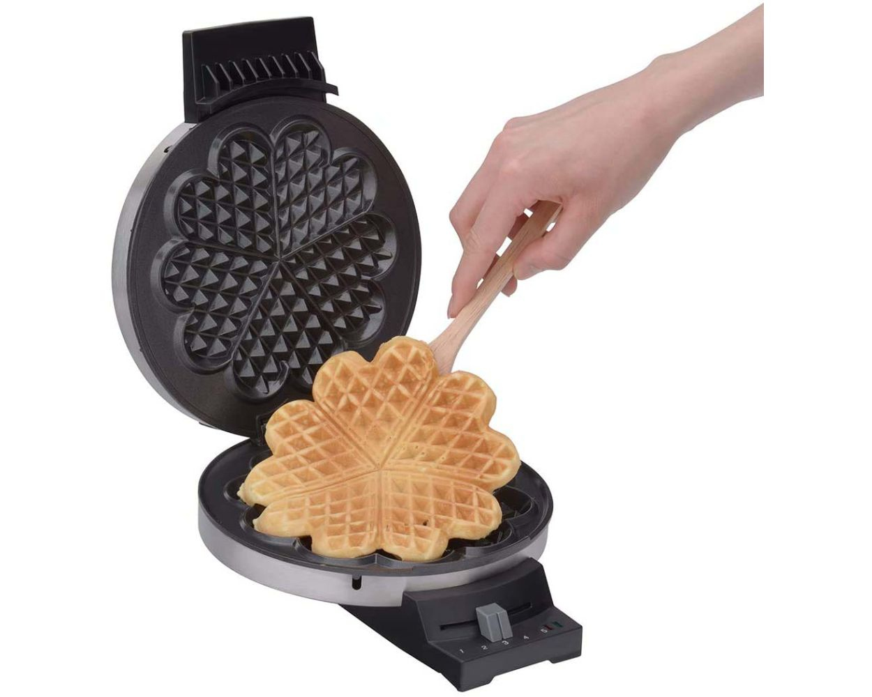 Gofrownica z gofrem w kształcie serca. Drewniana łyżka podnosi go.