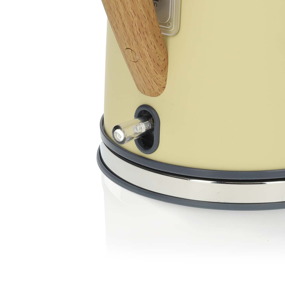 Zbliżenie kremowego czajnika z drewnianym uchwytem, pokazujące przycisk włączania/wyłączania.