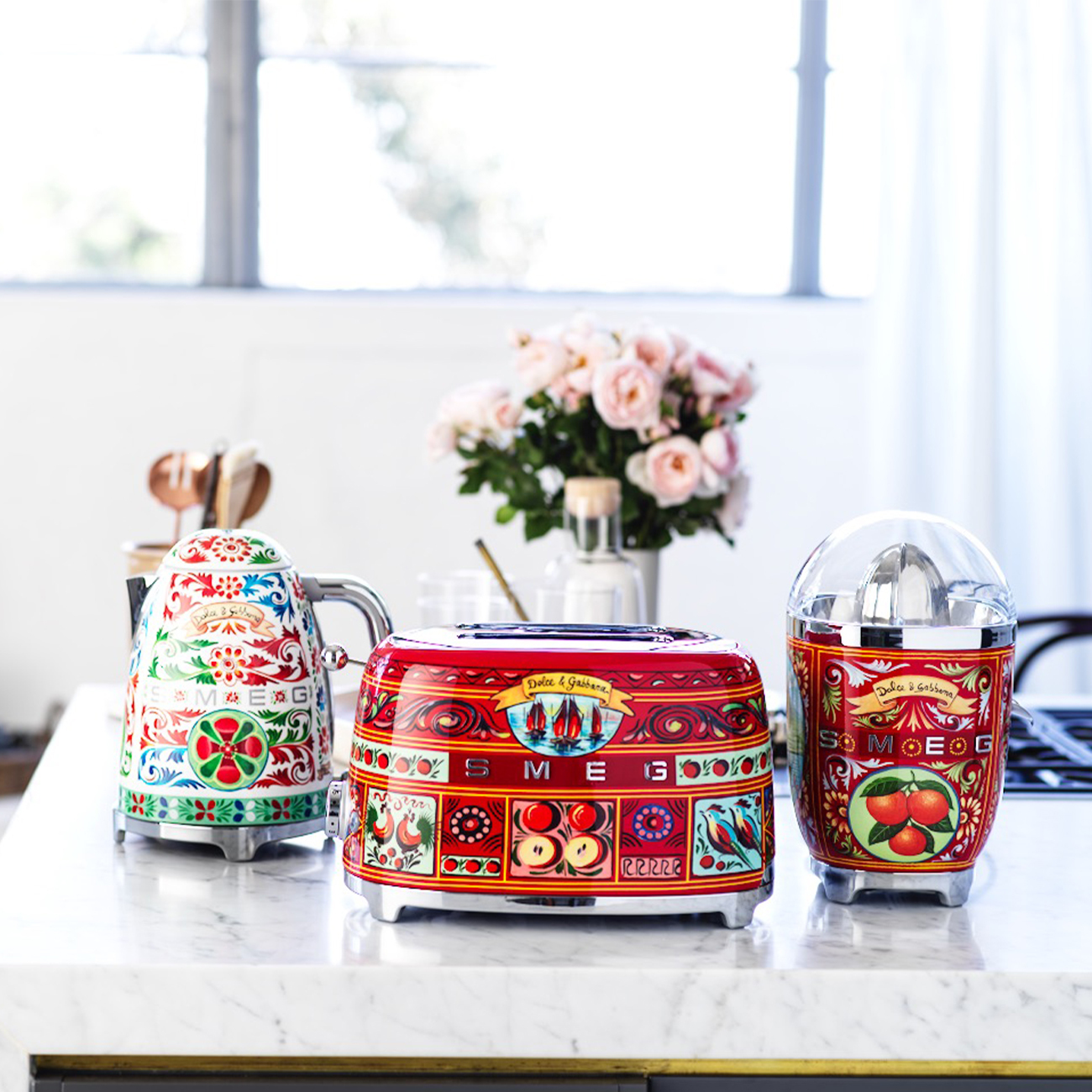 Eine Küchenszene mit einem Dolce & Gabbana Toaster, Entsafter und Wasserkocher mit floralen Mustern.