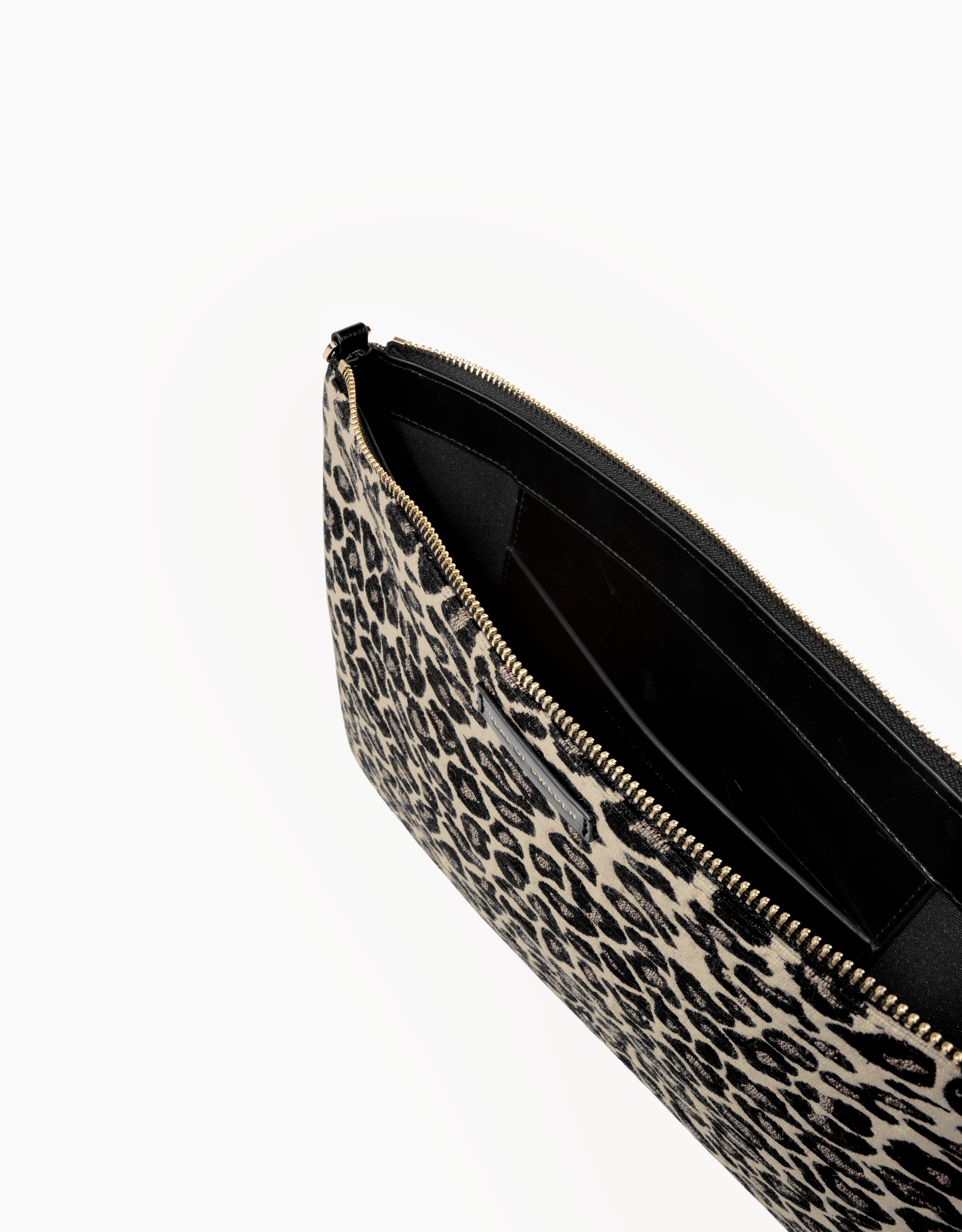 Bolso de mano con estampado de leopardo, abierto. Interior negro con cremallera dorada.