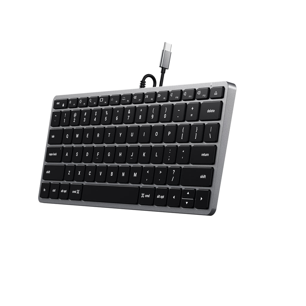 Tastiera argento con tasti neri e cavo USB-C. Sfondo bianco, vista angolata.