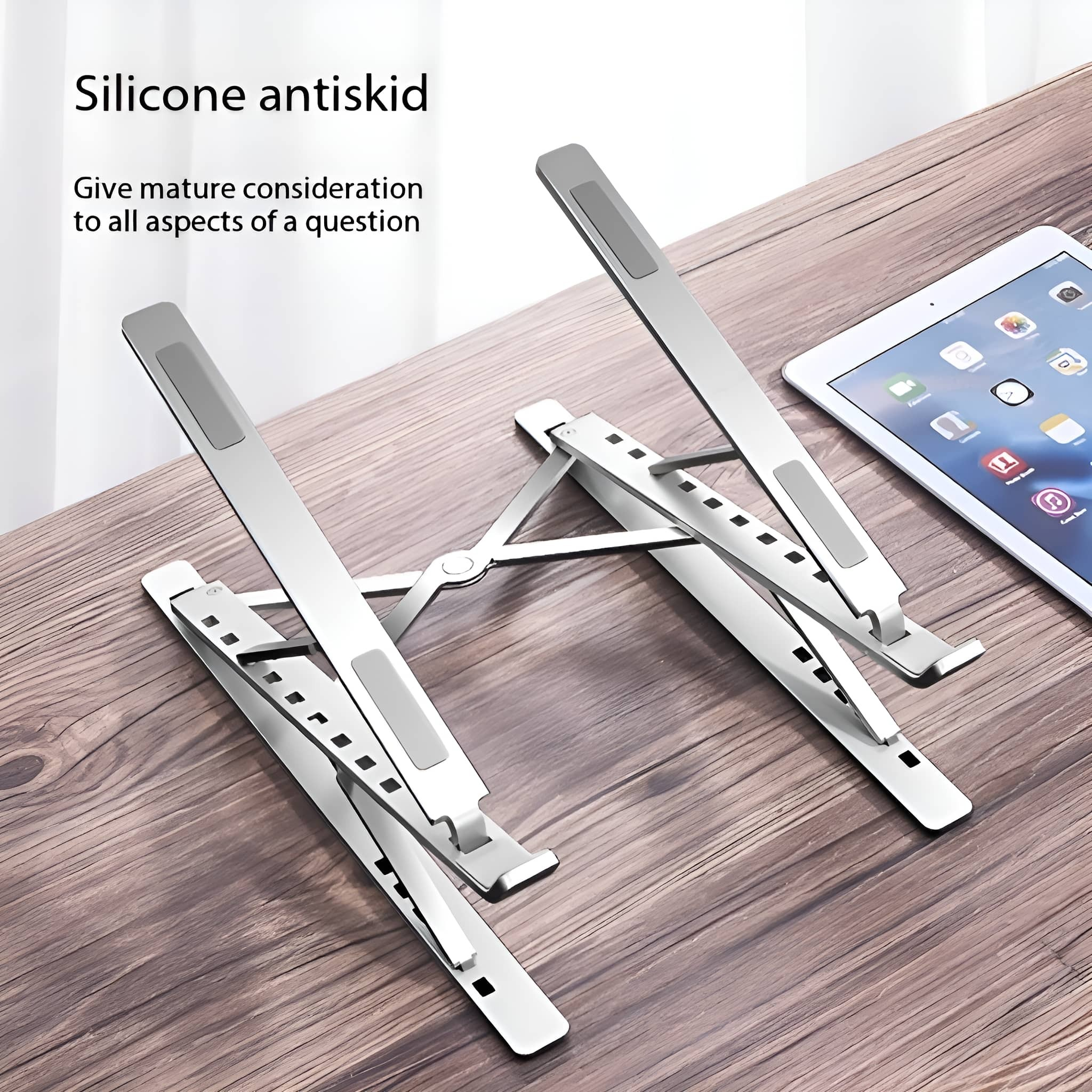 Silberner Laptop-Ständer. Zwei Teile mit Silikonpads, Tablet auf Holzoberfläche.