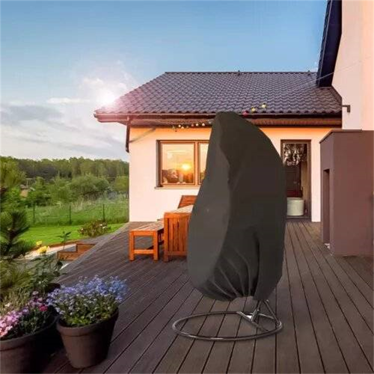 Stuhl mit schwarzem Stoff bedeckt auf einem Deck. Haus und Bäume im Hintergrund.