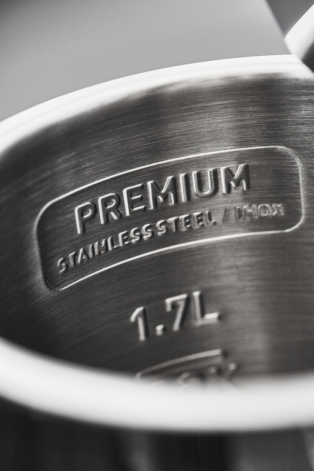 Zbliżenie na wnętrze stalowego czajnika, pokazujące napis 'PREMIUM' i pojemność 1,7L.