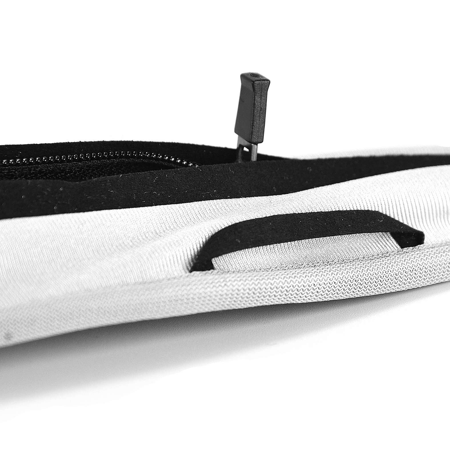 Primo piano di una pochette con cerniera bianca e nera. Cerniera aperta. Isolato su bianco.