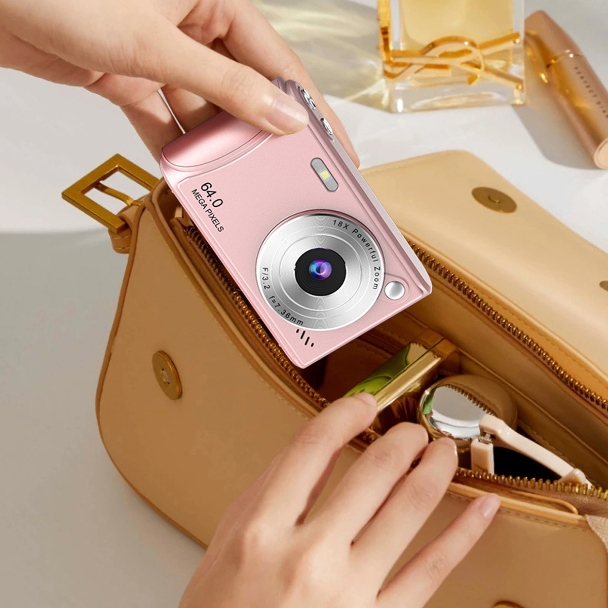 Eine rosa Kamera wird aus einer beigen Handtasche genommen. Andere Gegenstände befinden sich in der Tasche.