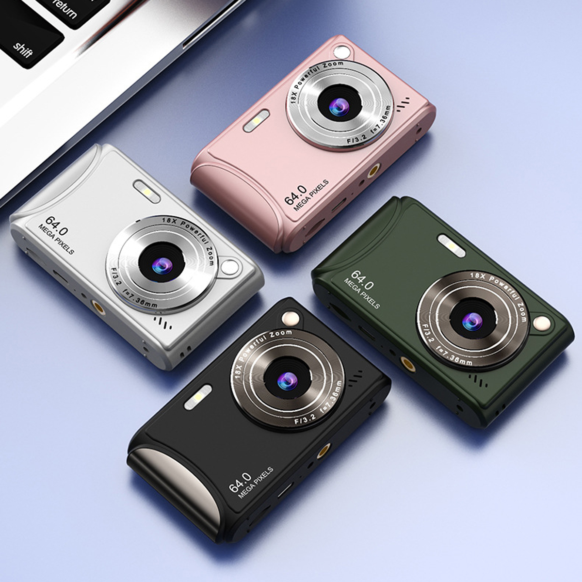 Vier kompakte Digitalkameras in verschiedenen Farben: Weiß, Rosa, Grün und Schwarz. Blaue Oberfläche.