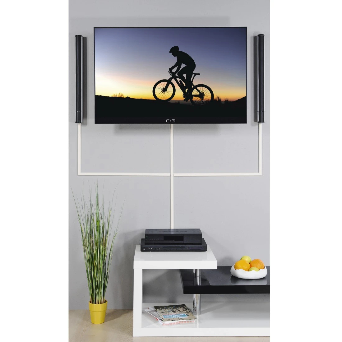 Un soggiorno con TV, altoparlanti e un tavolo con decorazioni.