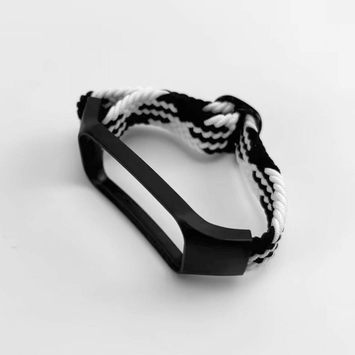 Schwarz-weiß geflochtenes Armband für eine Uhr oder einen Fitness-Tracker, mit einem schwarzen rechteckigen Rahmen.