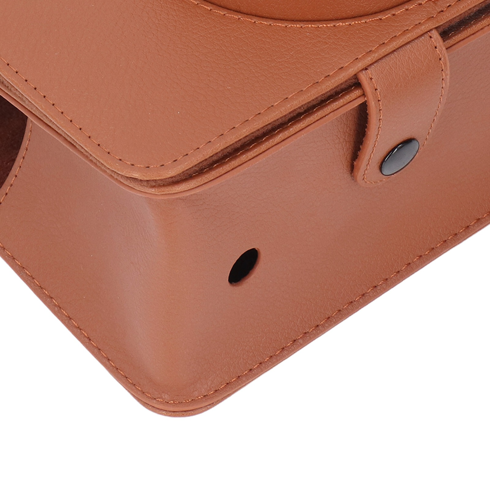 Nahaufnahme einer braunen Ledertasche. Ein Loch und ein Knopf sind an der Seite der Tasche zu sehen.