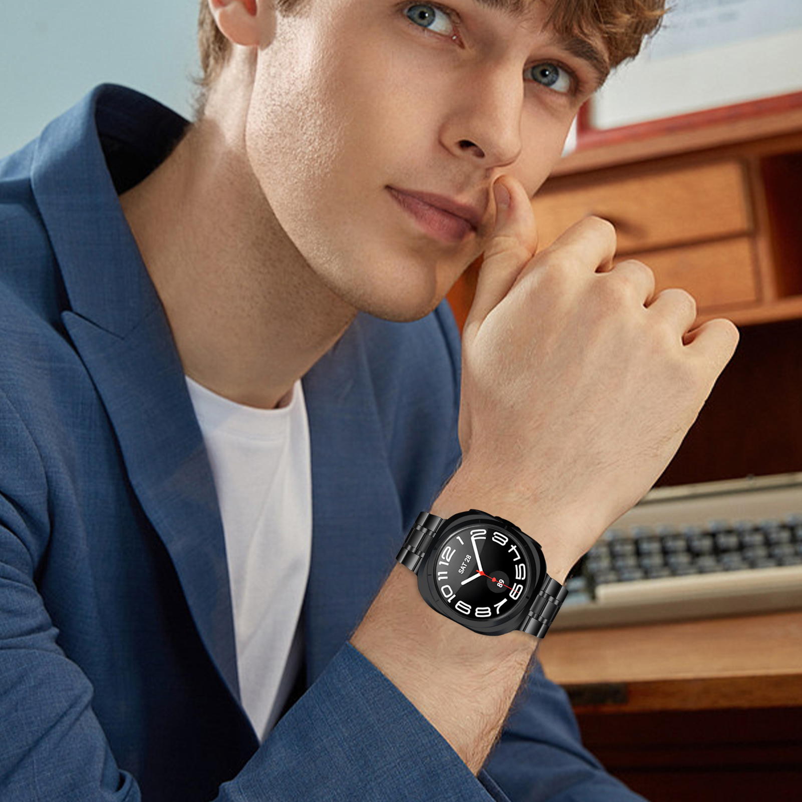 Mann mit schwarzer Uhr am Handgelenk. Die Uhr hat ein schwarzes Zifferblatt und ein silbernes Armband. Unscharfer Hintergrund.