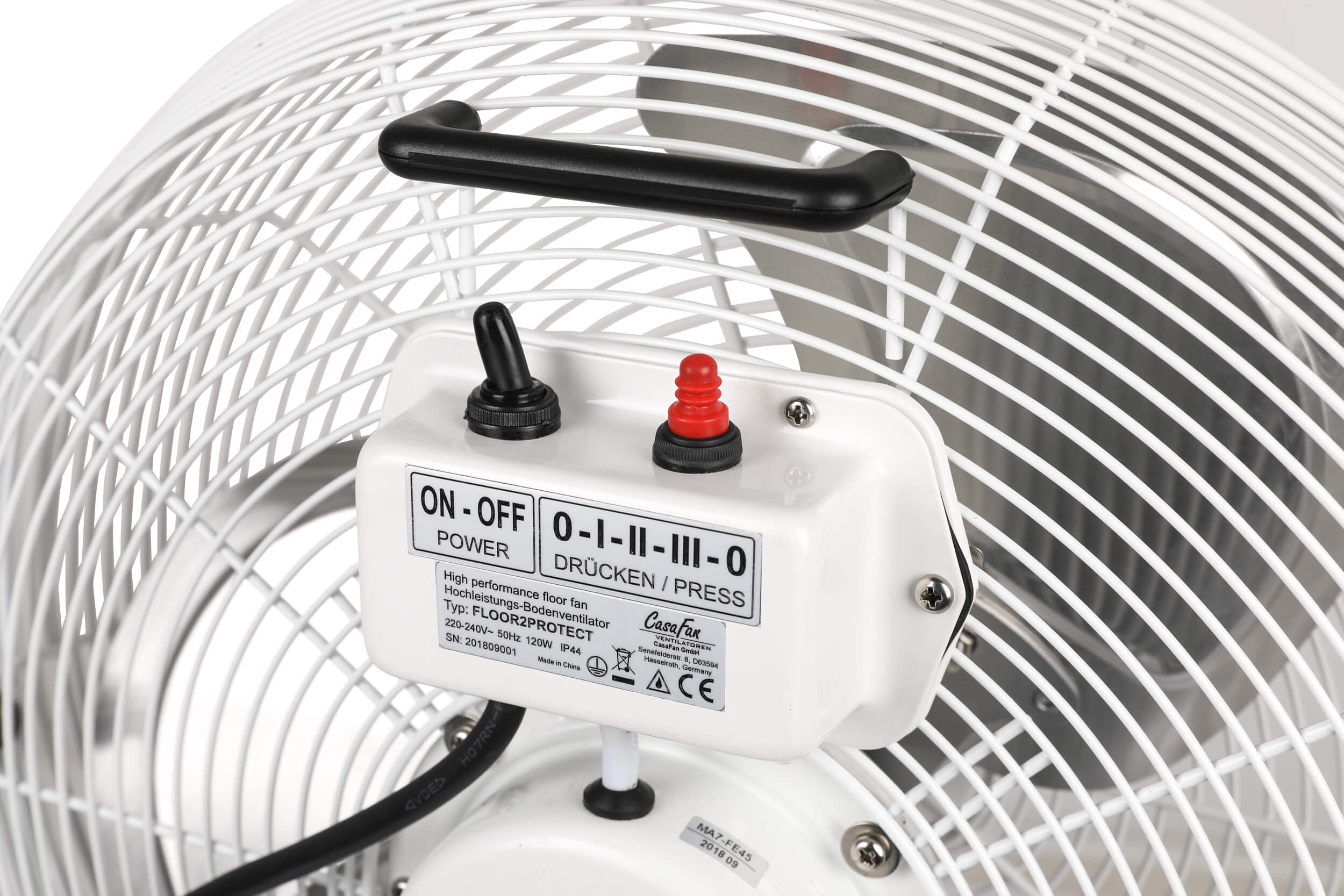 Un ventilatore bianco con una maniglia nera. Il ventilatore ha un pannello interruttori sul davanti.