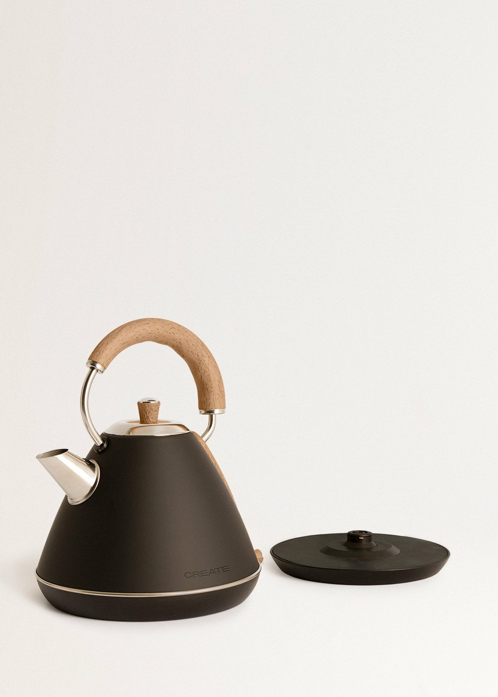 Hervidor negro con asa de madera y tapa. Fondo blanco, hervidor sobre una superficie.